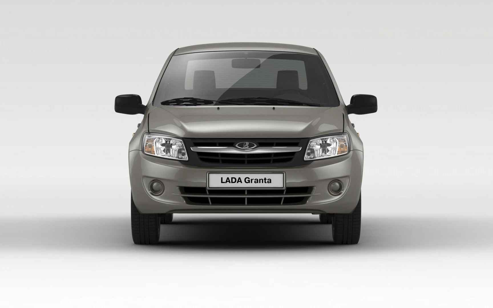 Ein grauer Lada Granta von vorne auf weißem Hintergrund, mit dem Logo und markanter Frontansicht.
