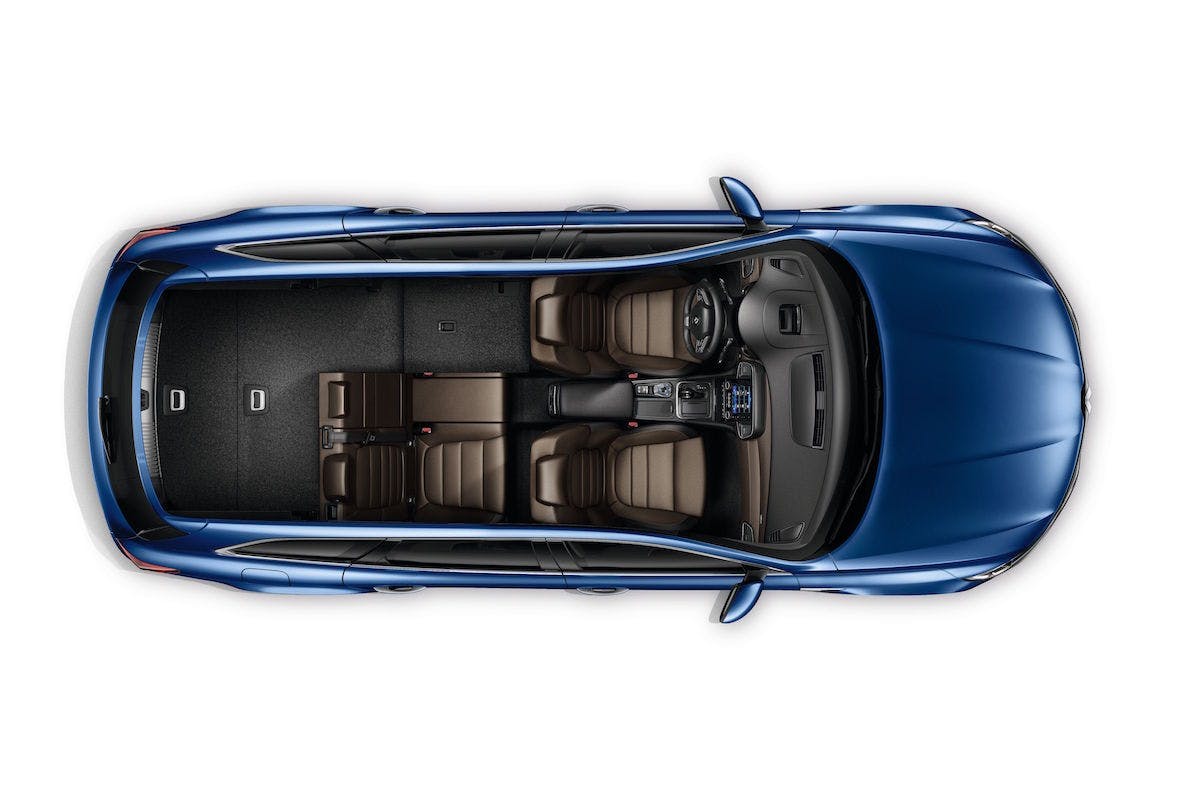Draufsicht eines blauen Autos mit 7 Sitzen. Die Rücksitze sind teils umgeklappt, braune Polsterung und moderne Innenausstattung sichtbar.