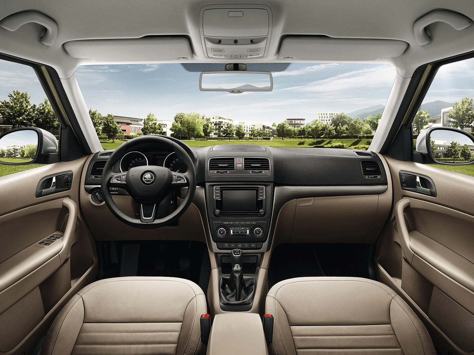 Innenraum eines Autos mit beige Ledersitzen, schwarzem Armaturenbrett und Blick durch die Windschutzscheibe auf eine grüne Landschaft.