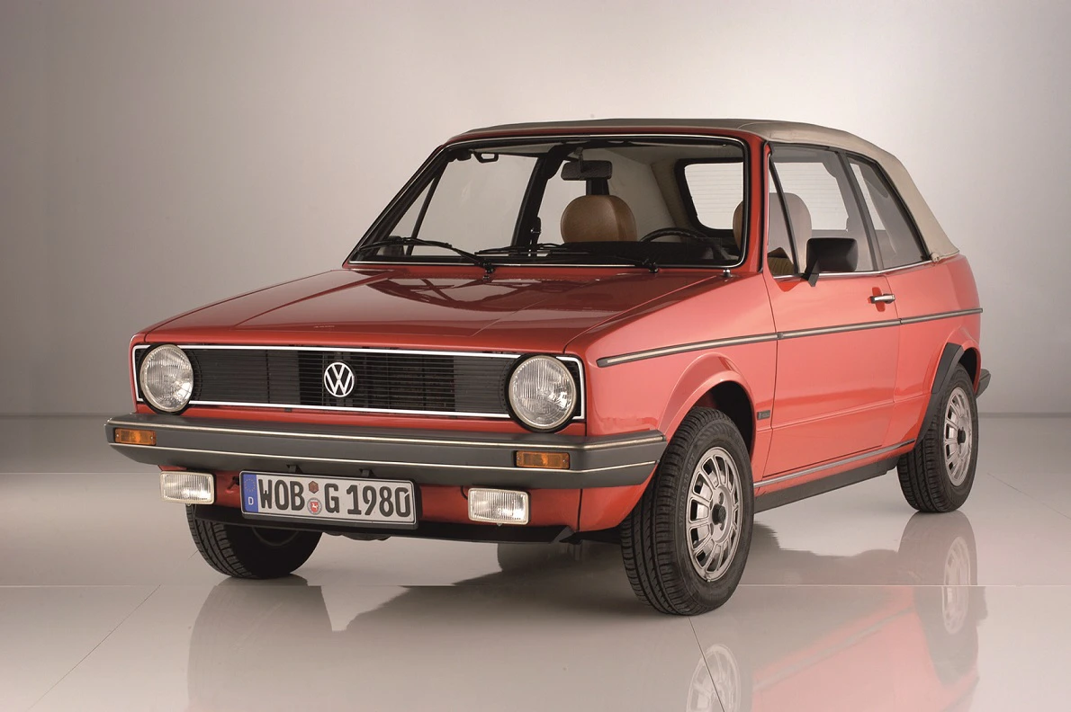 Roter, klassischer VW Golf Cabrio aus den 1980er Jahren, seitliche Frontansicht, vor neutralem Hintergrund.