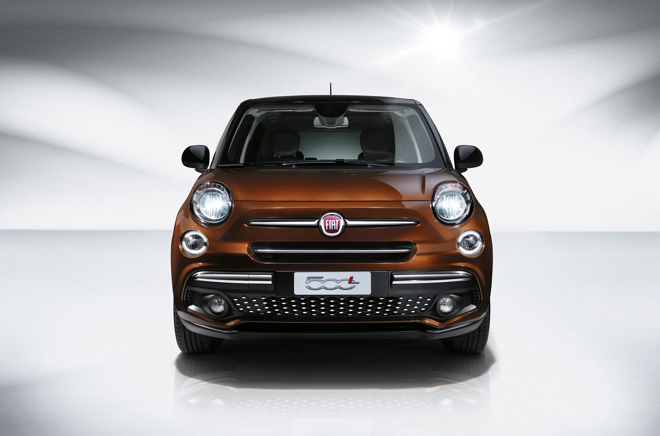 Brauner Fiat 500L, in einem hellen Studio fotografiert, von vorne mit sichtbarem Markenlogo und glänzenden Scheinwerfern.