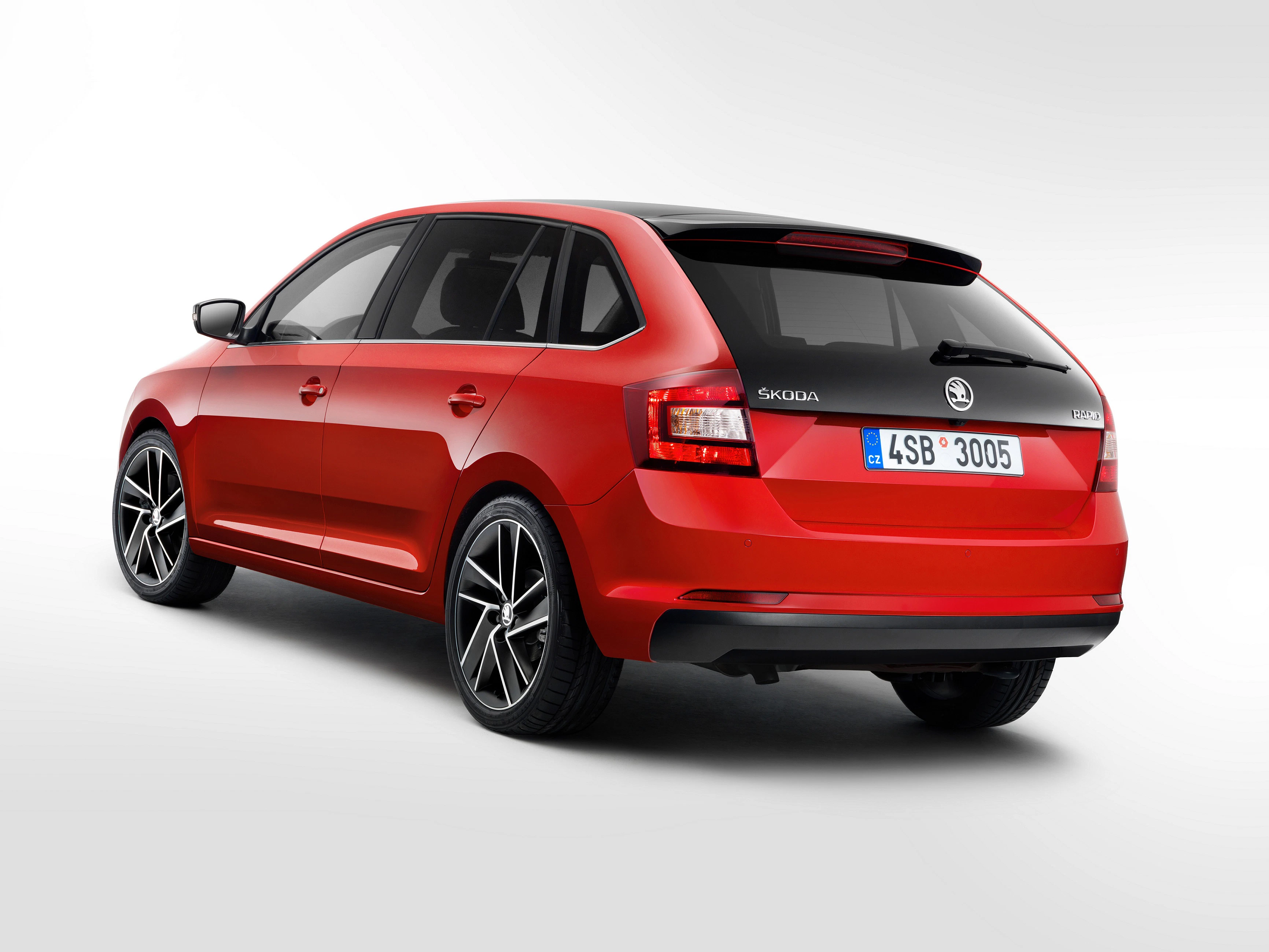Roter Škoda Kombi, Rückansicht auf weißem Hintergrund. Sportliches Design, schwarze Fensterrahmen, stilvolle Felgen.