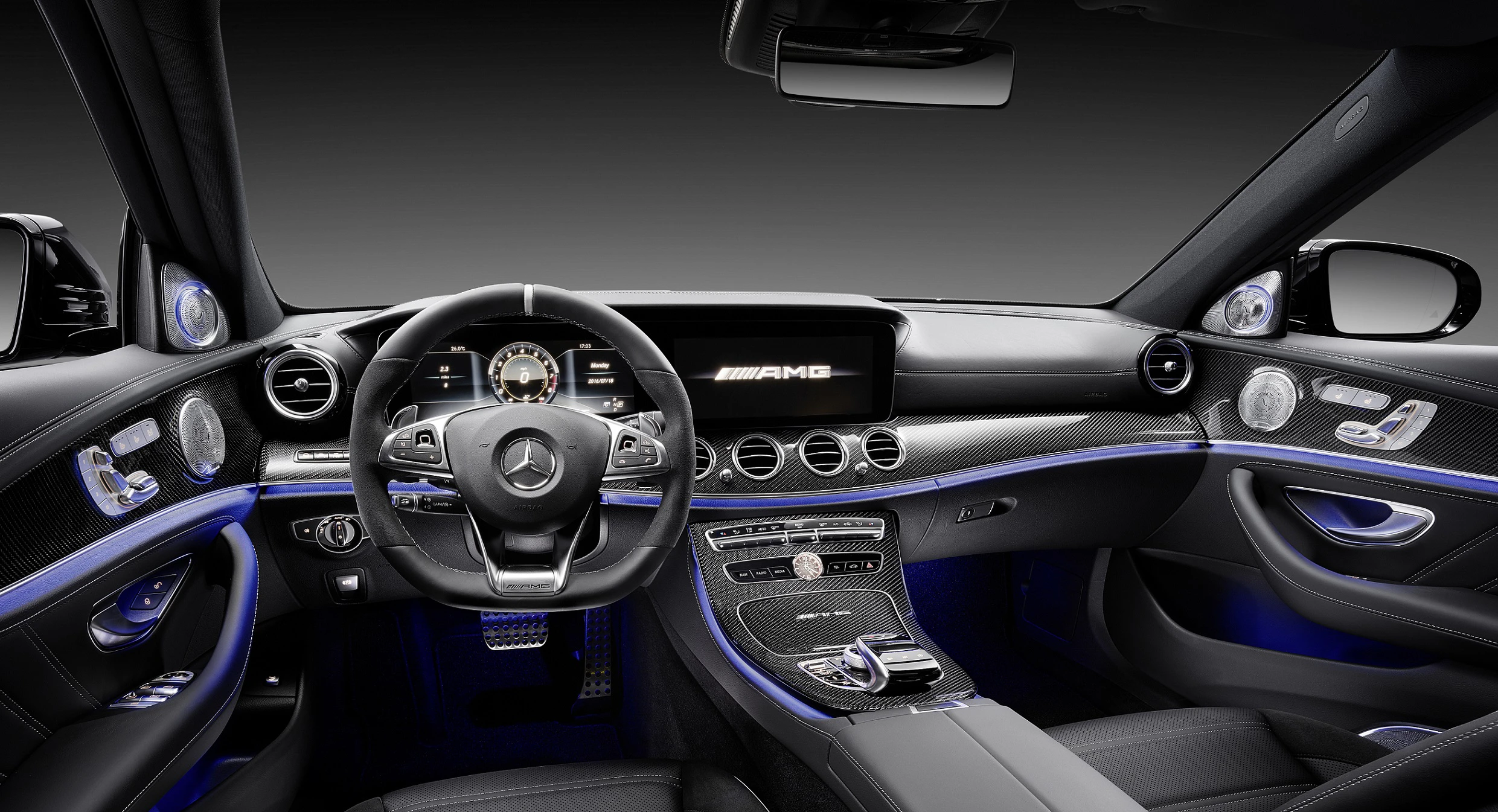 Innenraum eines sportlichen Mercedes. Luxuriöse Ausstattung mit Leder, Carbon-Elementen, digitalem Display und blauer Ambiente-Beleuchtung.