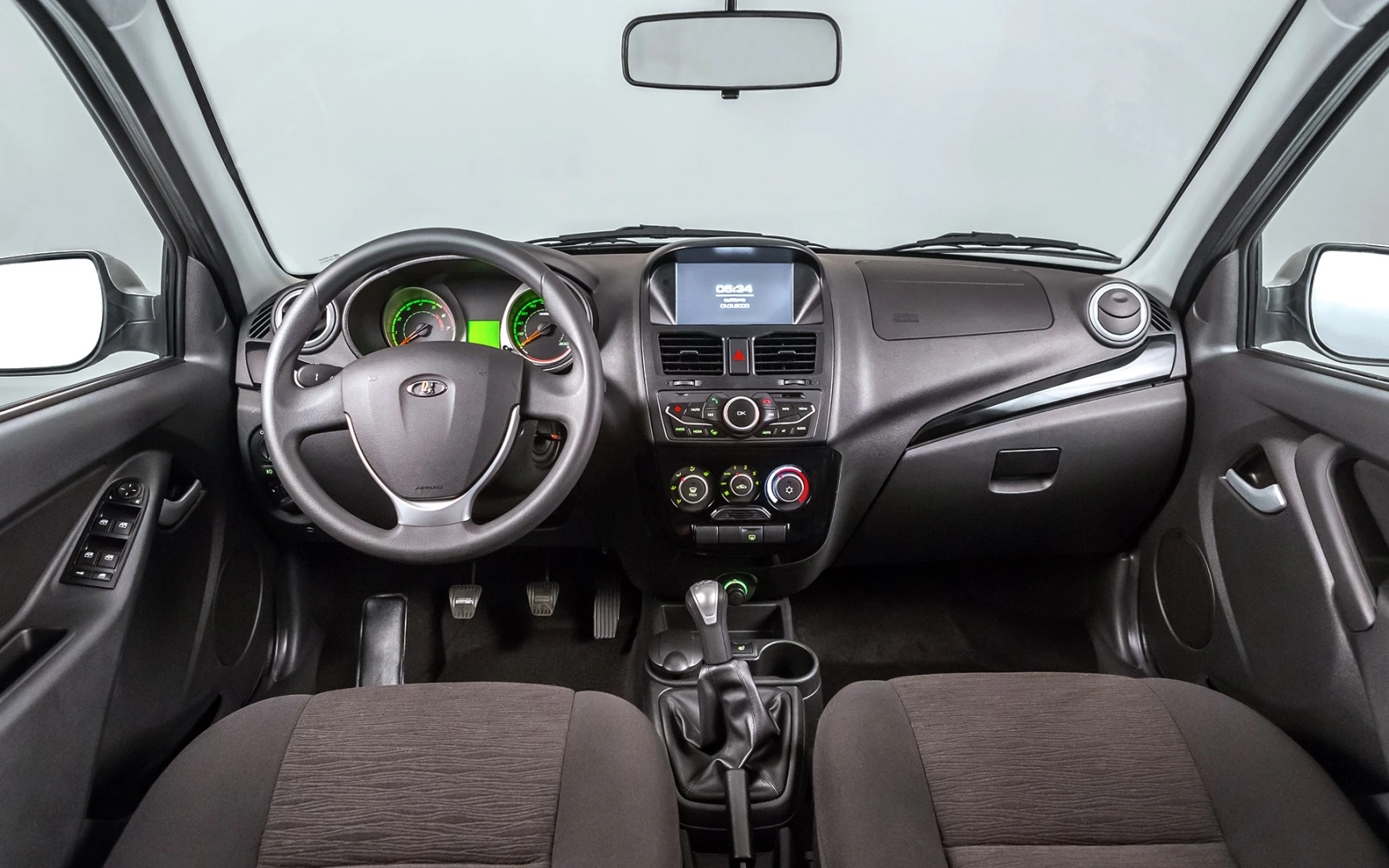 Innenraum eines Autos mit modernen Armaturen, Lenkrad links, zentrale Konsole mit Display, und manueller Gangschaltung.