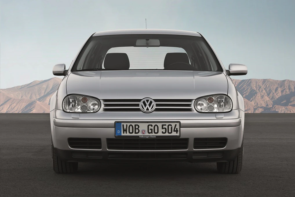 Silberner Volkswagen Golf steht auf Asphalt vor einer Wüstenkulisse. Klarer Himmel im Hintergrund.