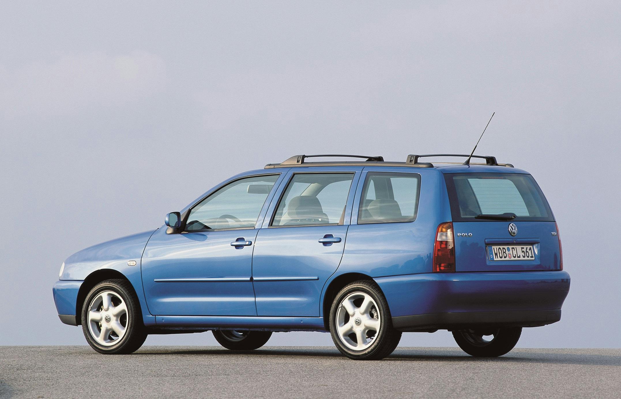Blauer Kombi auf einer Straße, seitlich von hinten gezeigt, gegen einen blauen Himmel. Dachträger und silberne Felgen sichtbar.