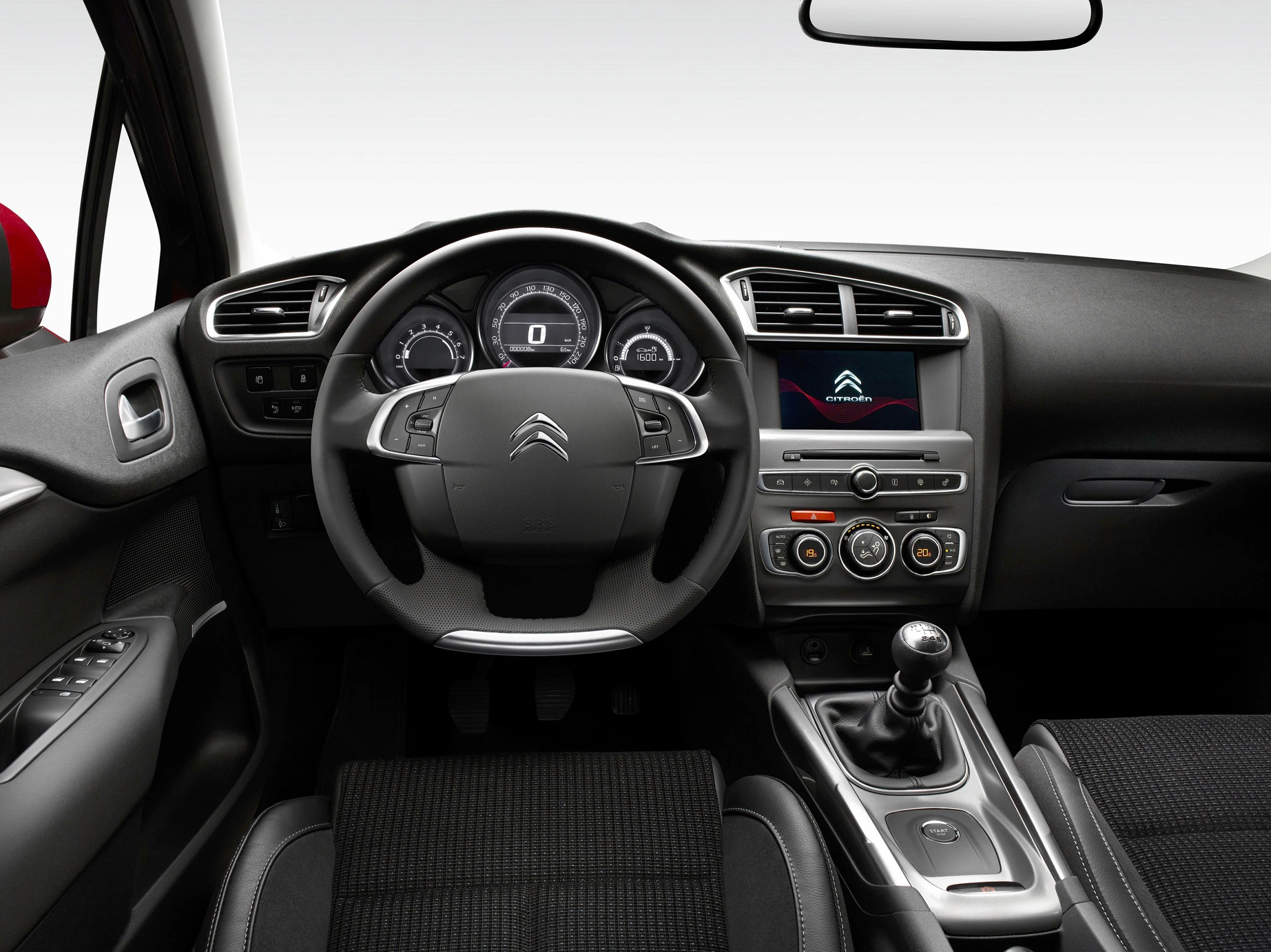 Innenraum eines Citroën mit Lenkrad, Armaturenbrett und Mittelkonsole. Schaltknauf und Kontrollbildschirm sind sichtbar.