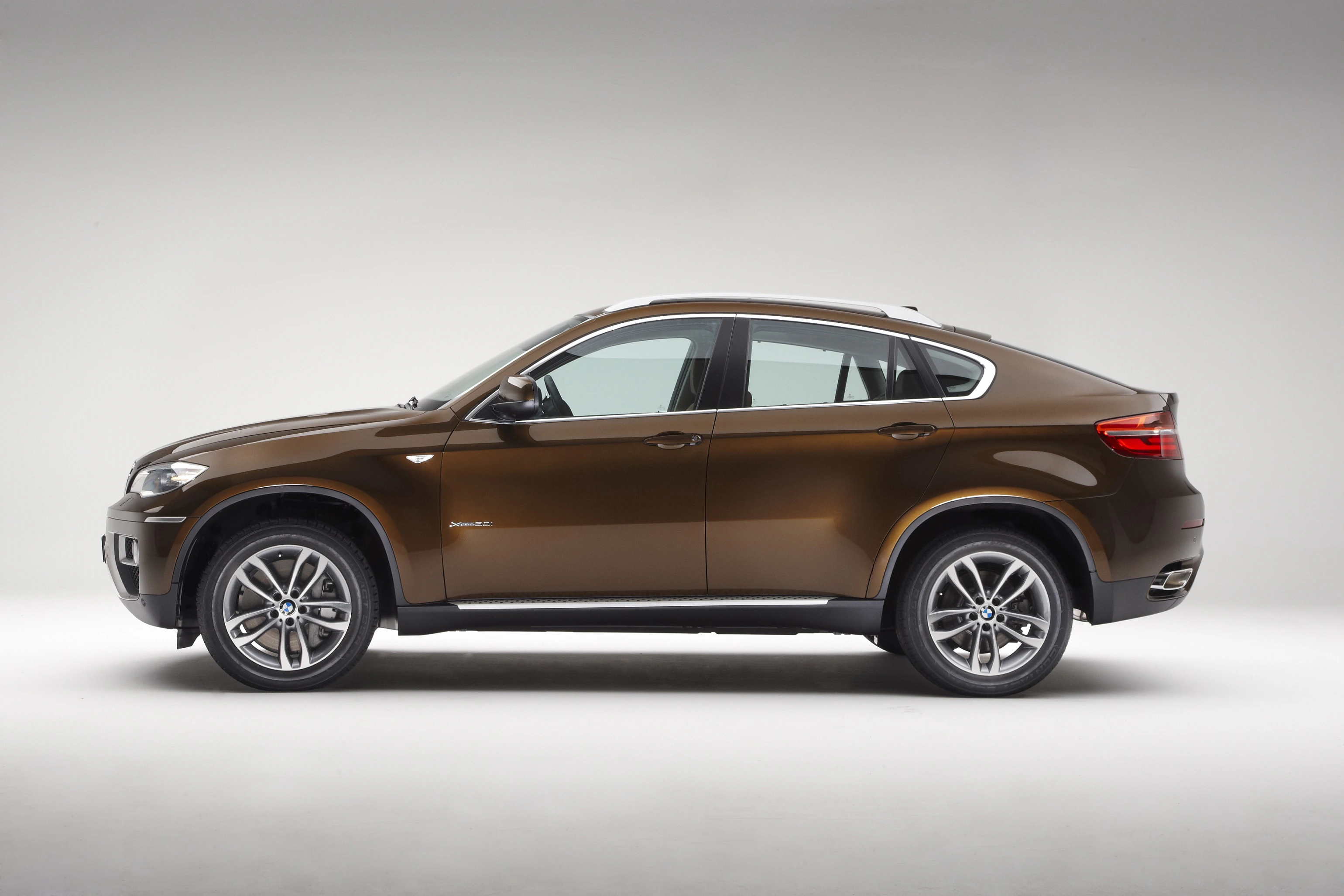 Braunes SUV im Profil auf grauem Hintergrund. Elegantes Design mit fünf Türen und Aluminiumfelgen.