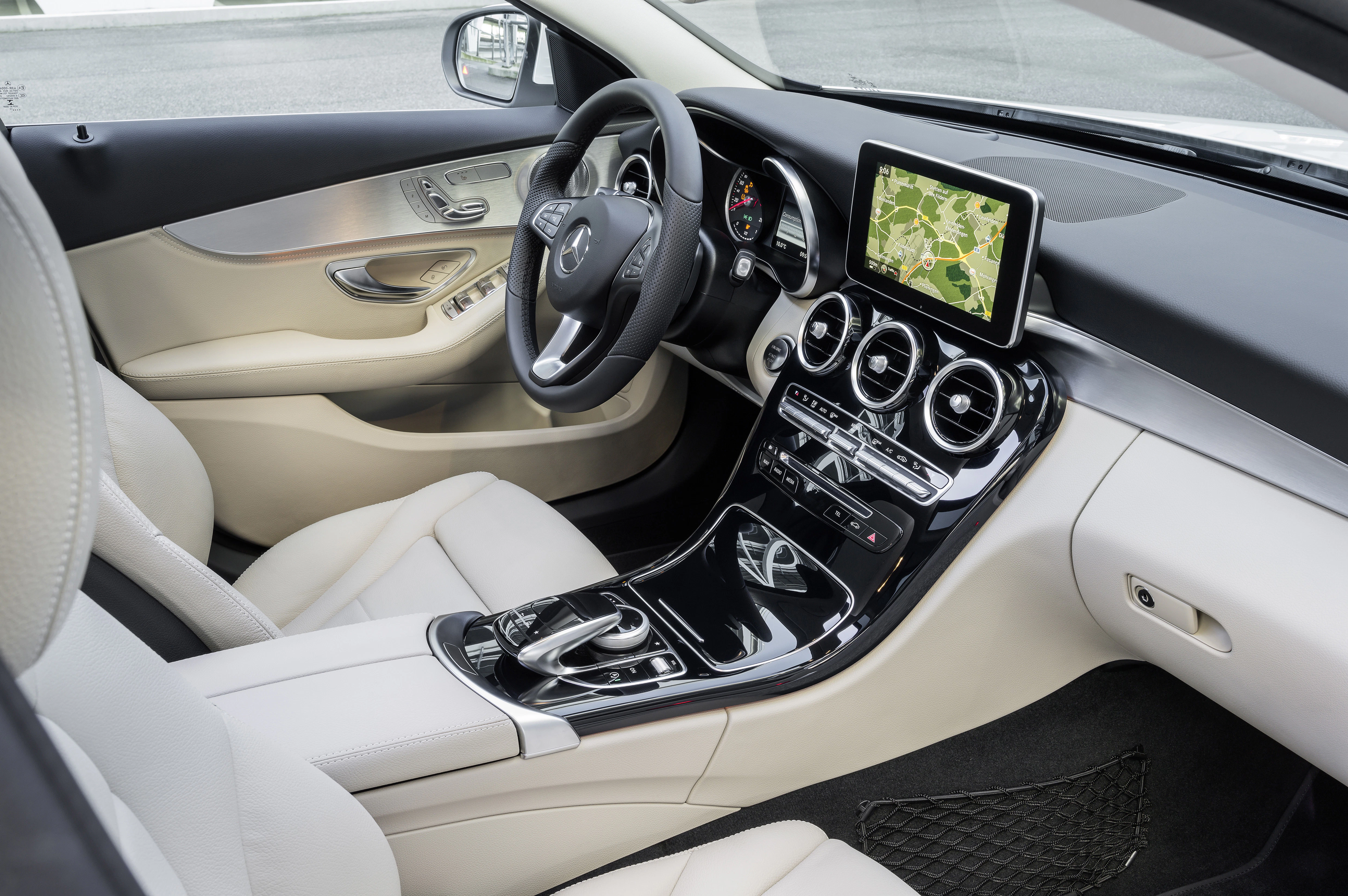 Innenraum eines modernen Autos mit beigem Leder, Touchscreen-Navigation, Lüftungsdüsen und stilvollem Armaturenbrett.