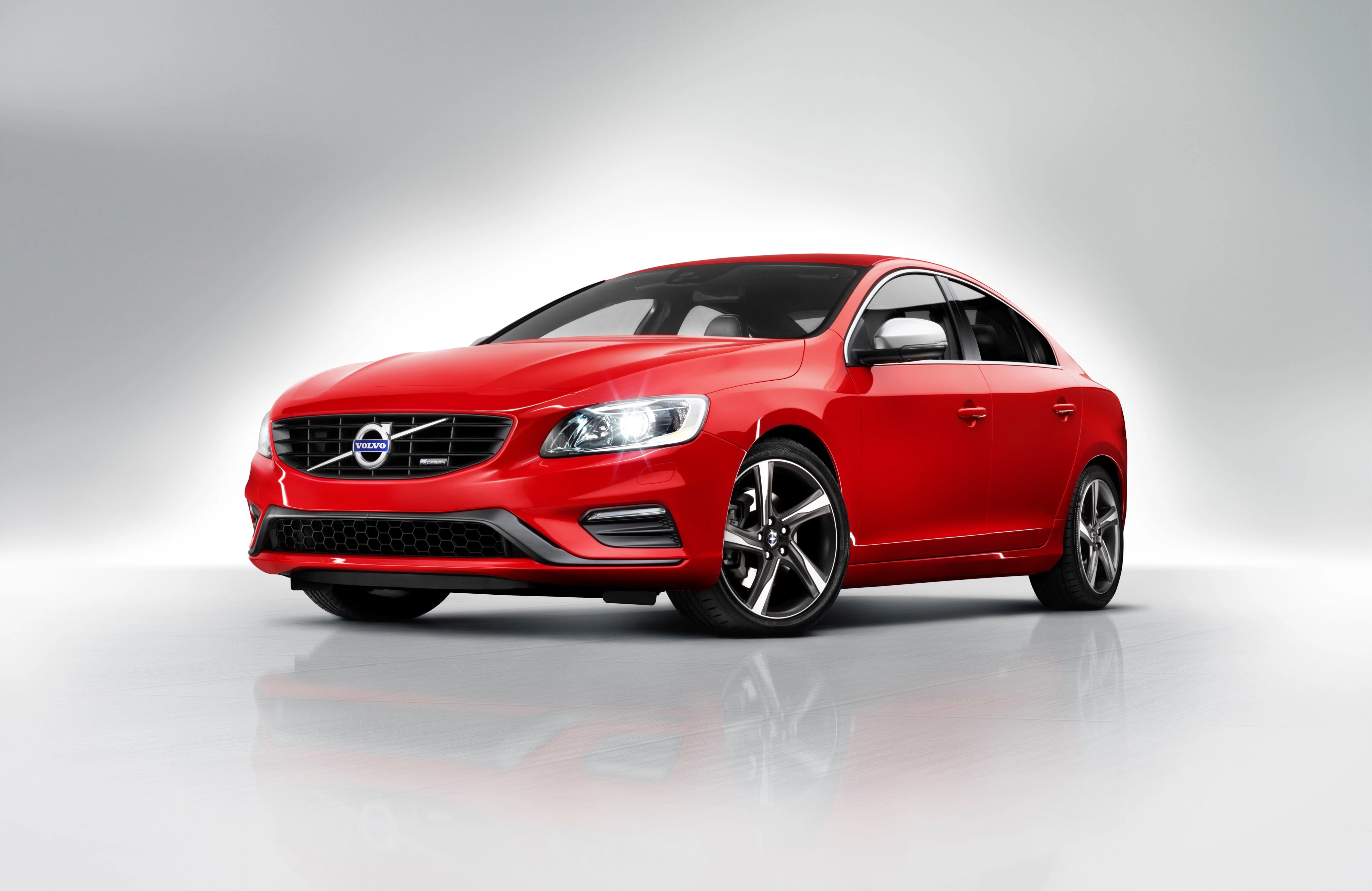 Rotes Auto im Studio, leicht schräg von vorne fotografiert; elegantes Design mit glänzenden Felgen und stilvoller Frontpartie.