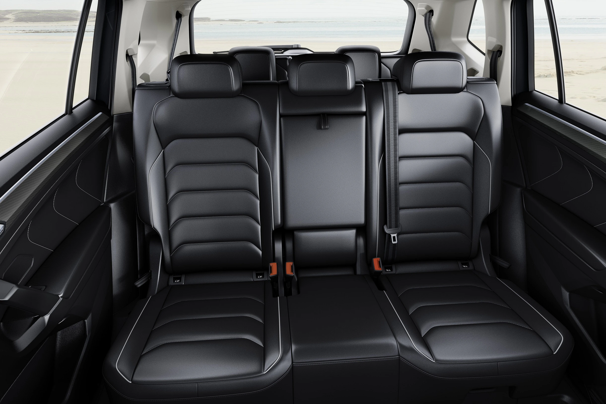 Schwarze Ledersitze in einem geräumigen Auto, Rücksitze mit Mittelarmlehne und Sicherheitsgurten, heller Himmel durch Rückfenster sichtbar.