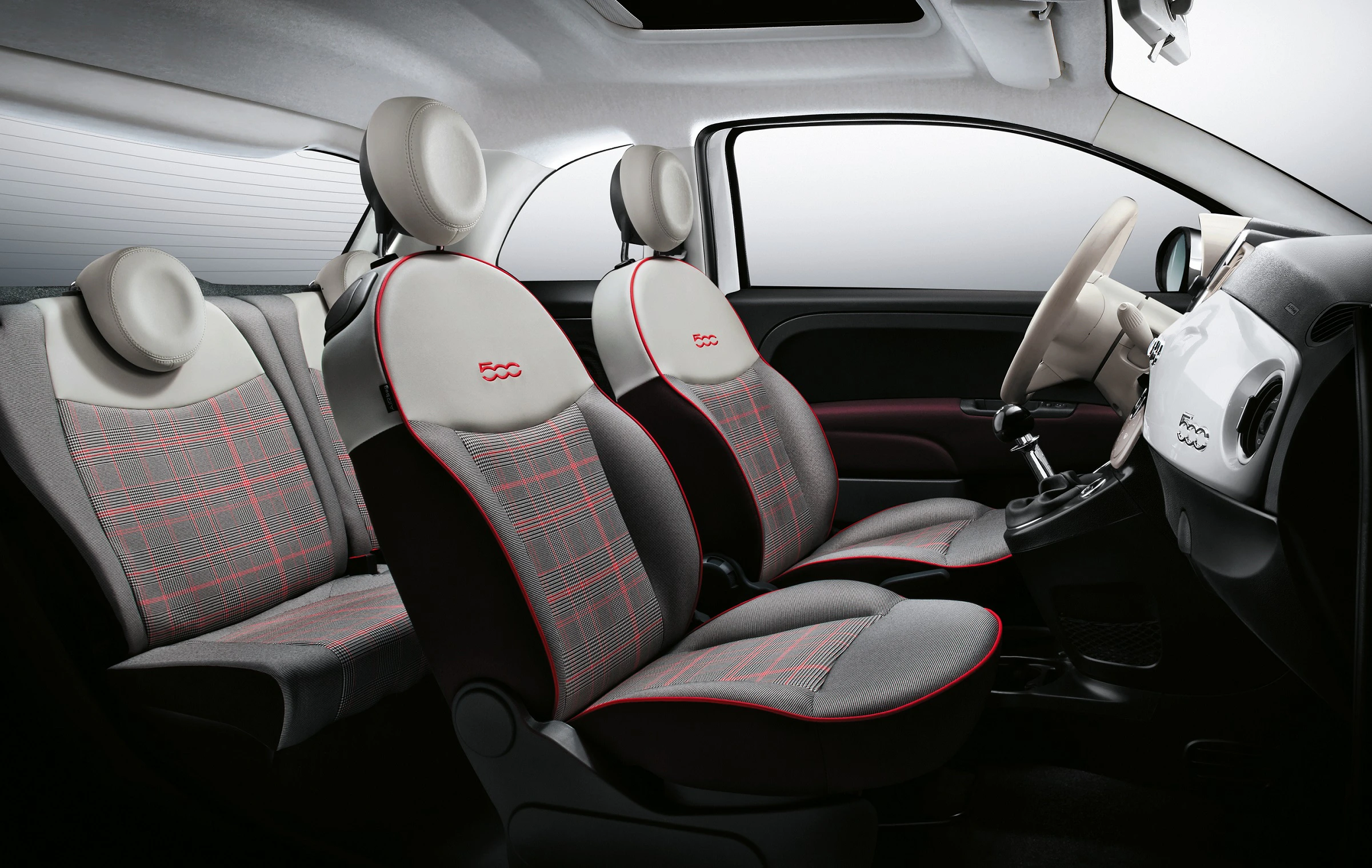 Innenraum eines Autos mit modernen Sitzen in Grau und Creme, roten Nähten, Lenkrad links. Helle und ergonomische Gestaltung.