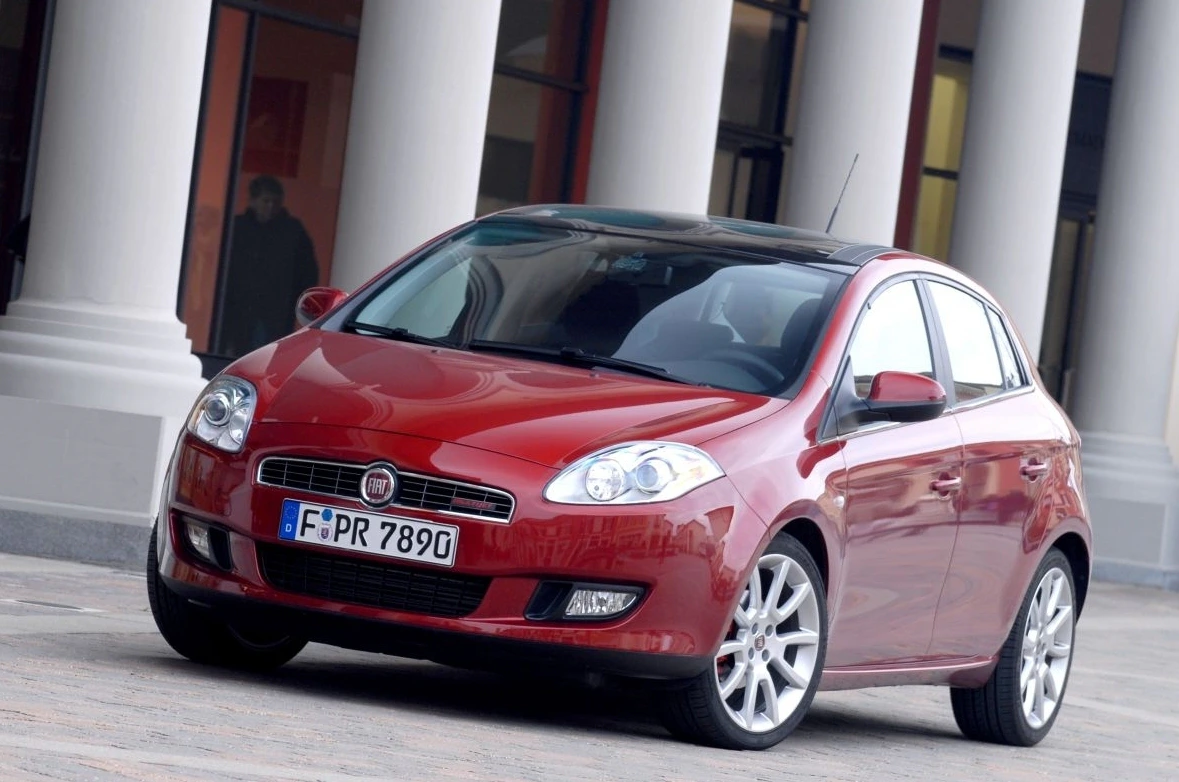Roter Fiat Bravo parkt vor einem Gebäude mit Säulen. Der Wagen hat ein deutsches Kennzeichen und silberne Felgen.