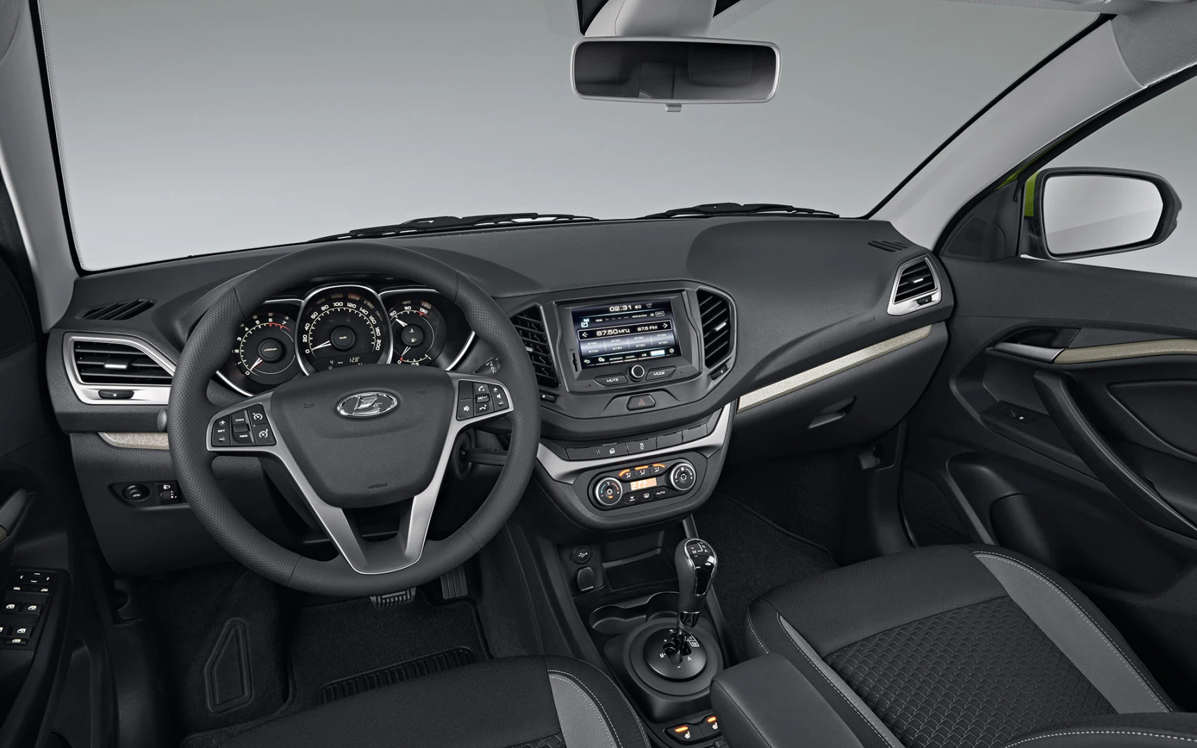 Autoinnenraum in Schwarz und Grau mit Multifunktionslenkrad, Touchscreen-Display, Lüftungsschlitzen und Mittelkonsole mit Schaltknauf.