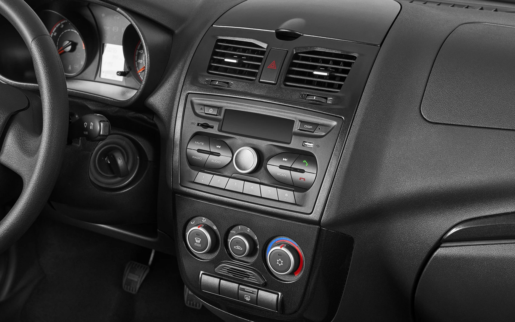 Armaturenbrett eines Autos mit Lüftungsschlitzen, Drehknöpfen und Tachos. Steuerung für Klimaanlage und Radio sichtbar.
