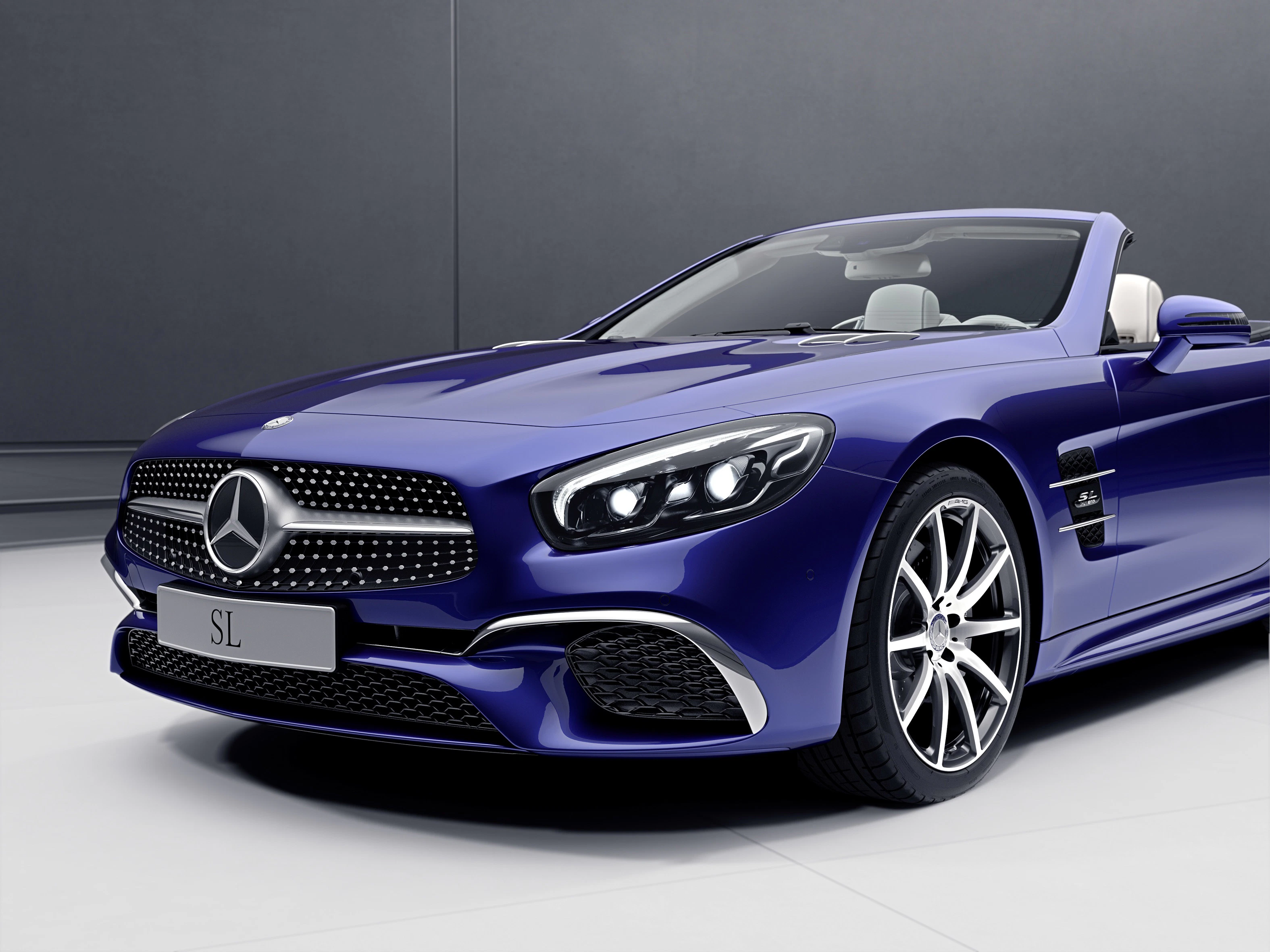 Blaues Mercedes-Benz SL Cabriolet, elegant mit LED-Scheinwerfern und sportlicher Frontansicht vor neutralem Hintergrund.