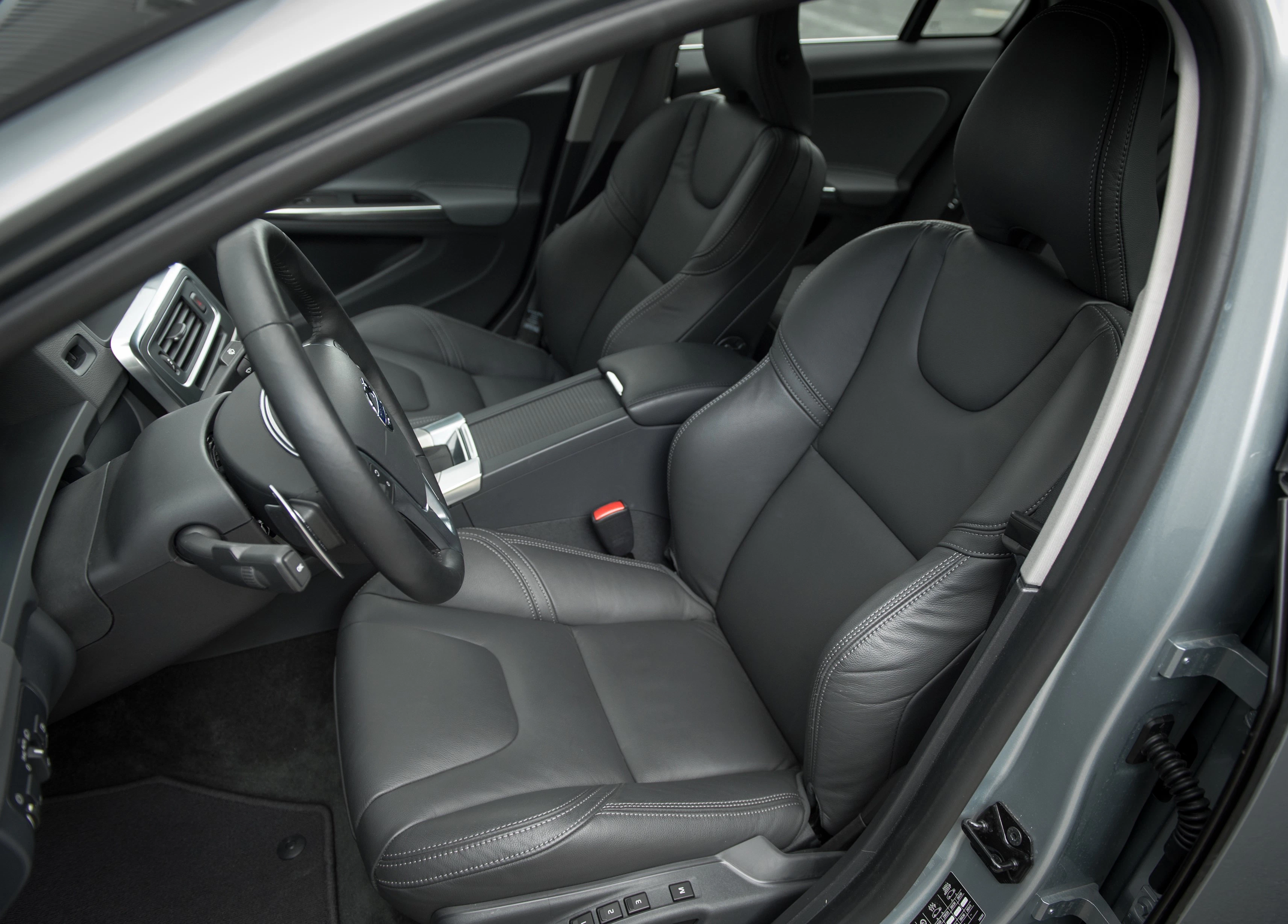Innenraum eines Autos mit eleganten, schwarzen Ledersitzen und modernen Armaturen. Fahrer- und Beifahrersitz sind sichtbar.