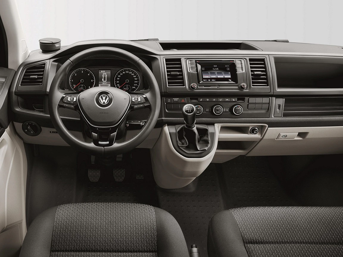 Innenraum eines Volkswagen-Fahrzeugs. Klassisches Armaturenbrett mit Lenkrad, Schalthebel, Rundinstrumenten und Infotainment-Bildschirm.