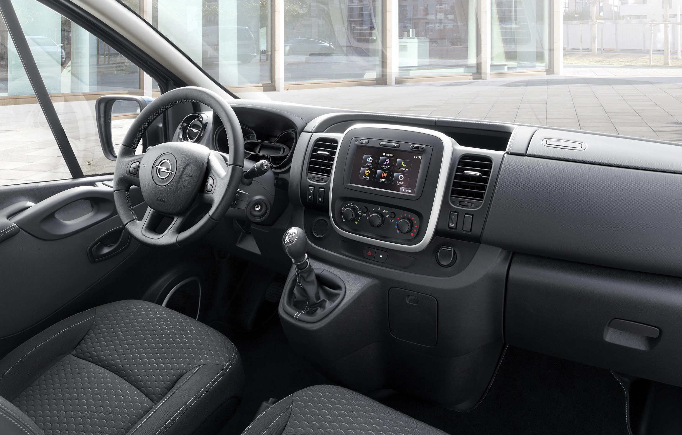 Innenraum eines modernen Autos mit schwarzem Armaturenbrett, Lenkrad, Schaltknüppel und Touchscreen-Display in der Mittelkonsole.