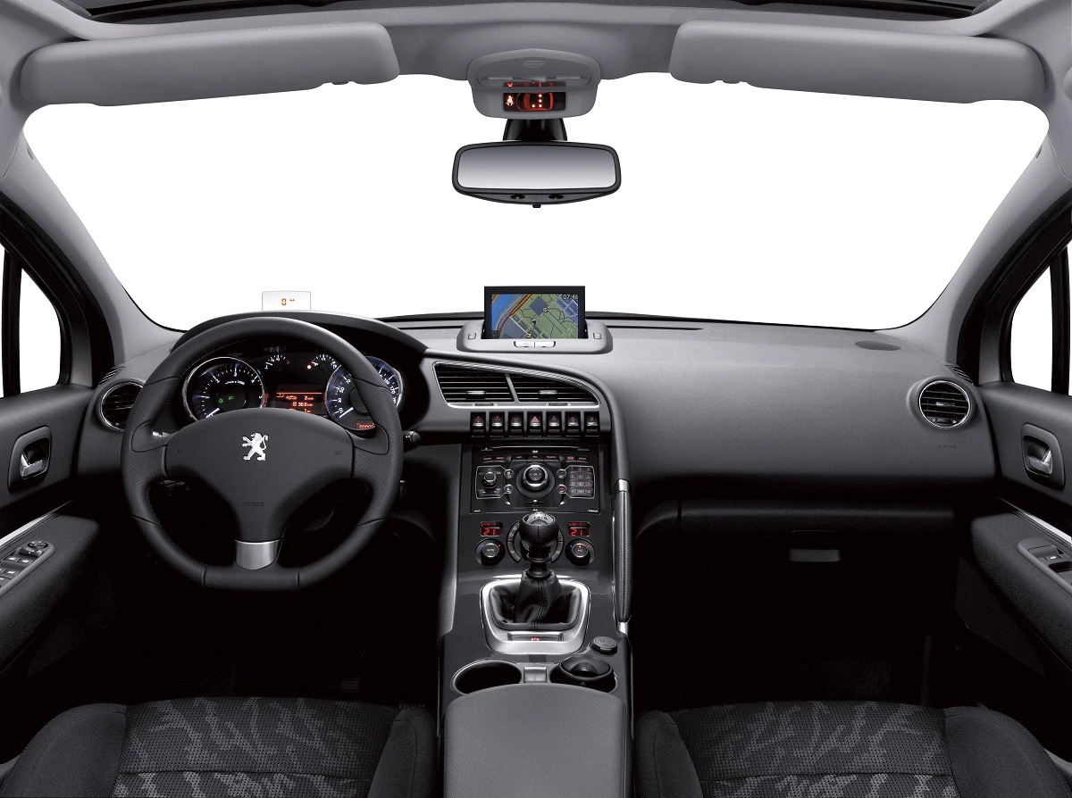 Innenraum eines Peugeot-Autos, modernes Armaturenbrett mit Lenkrad, Navigationsbildschirm und Mittelkonsole, schwarz-graues Interieur.