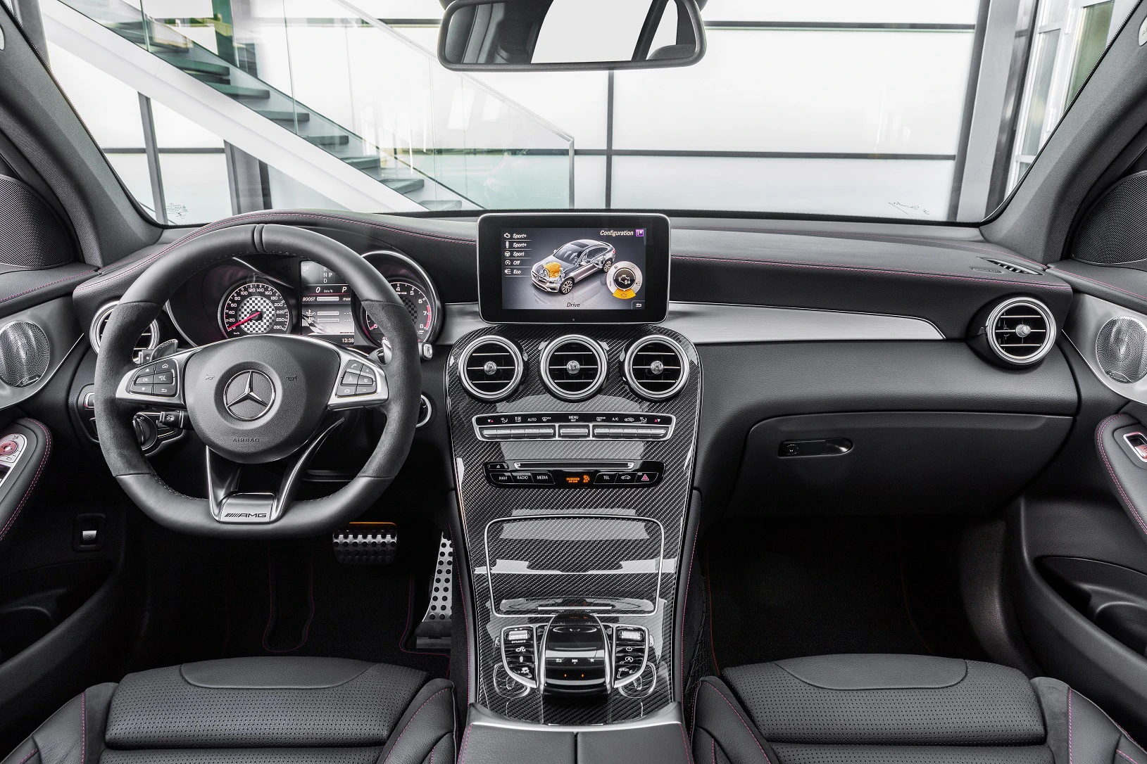 Innenraum eines Mercedes-Benz mit Lenkrad, Touchscreen-Display, Belüftungsdüsen und Mittelkonsole in einem modernen, luxuriösen Design.