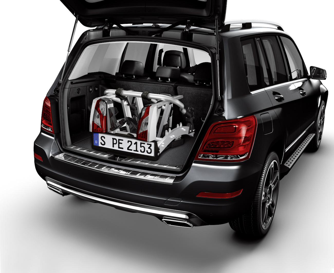 Schwarzer SUV mit geöffneter Heckklappe, in dem zwei zusammengeklappte Kinderwagen im Kofferraum verstaut sind.