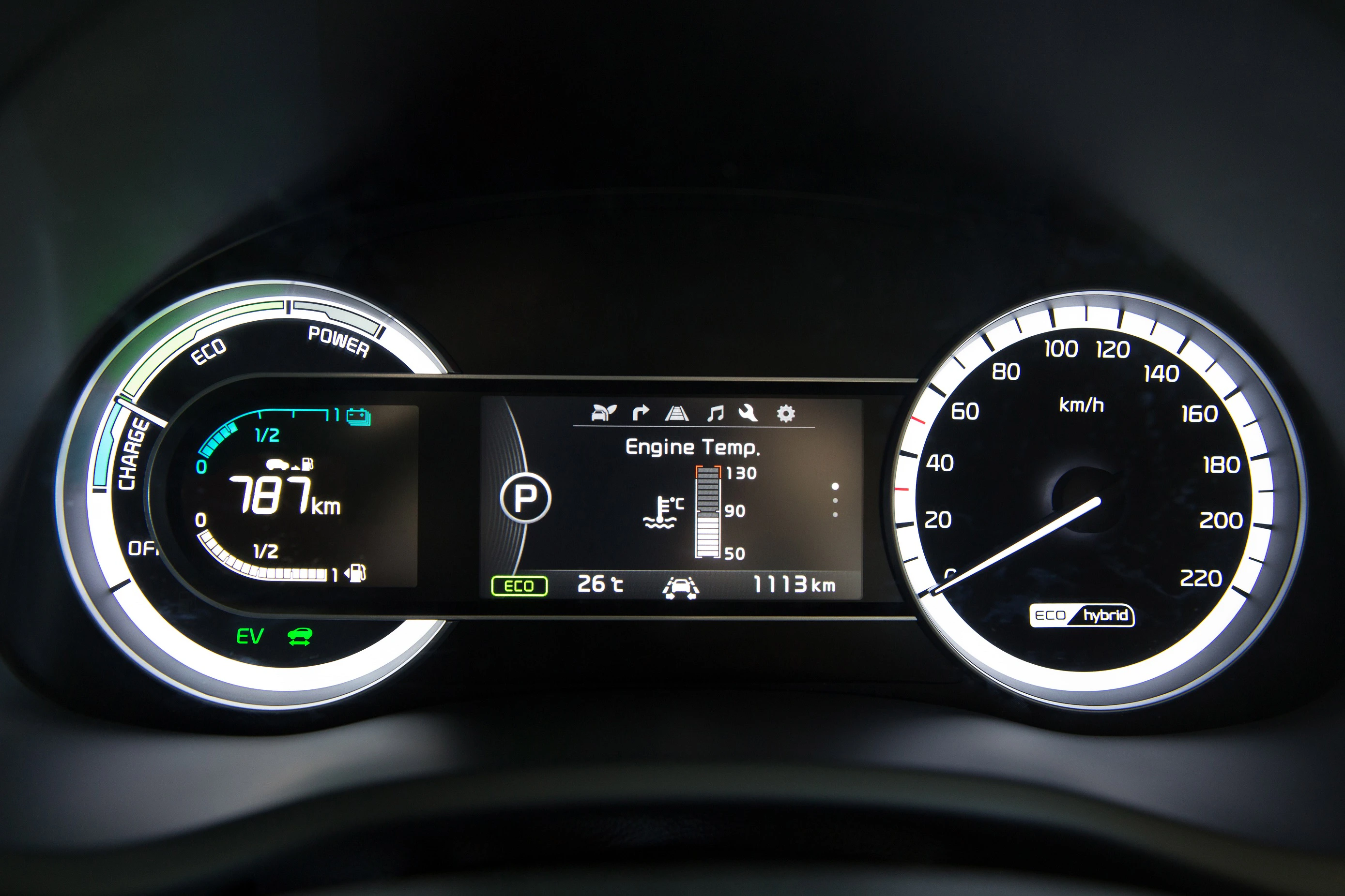 Digitales Armaturenbrett eines Autos mit Geschwindigkeitsanzeige, Ladestatus, Fahrmodus und Reichweite. 787 km verbleibend, 1113 km gefahren.