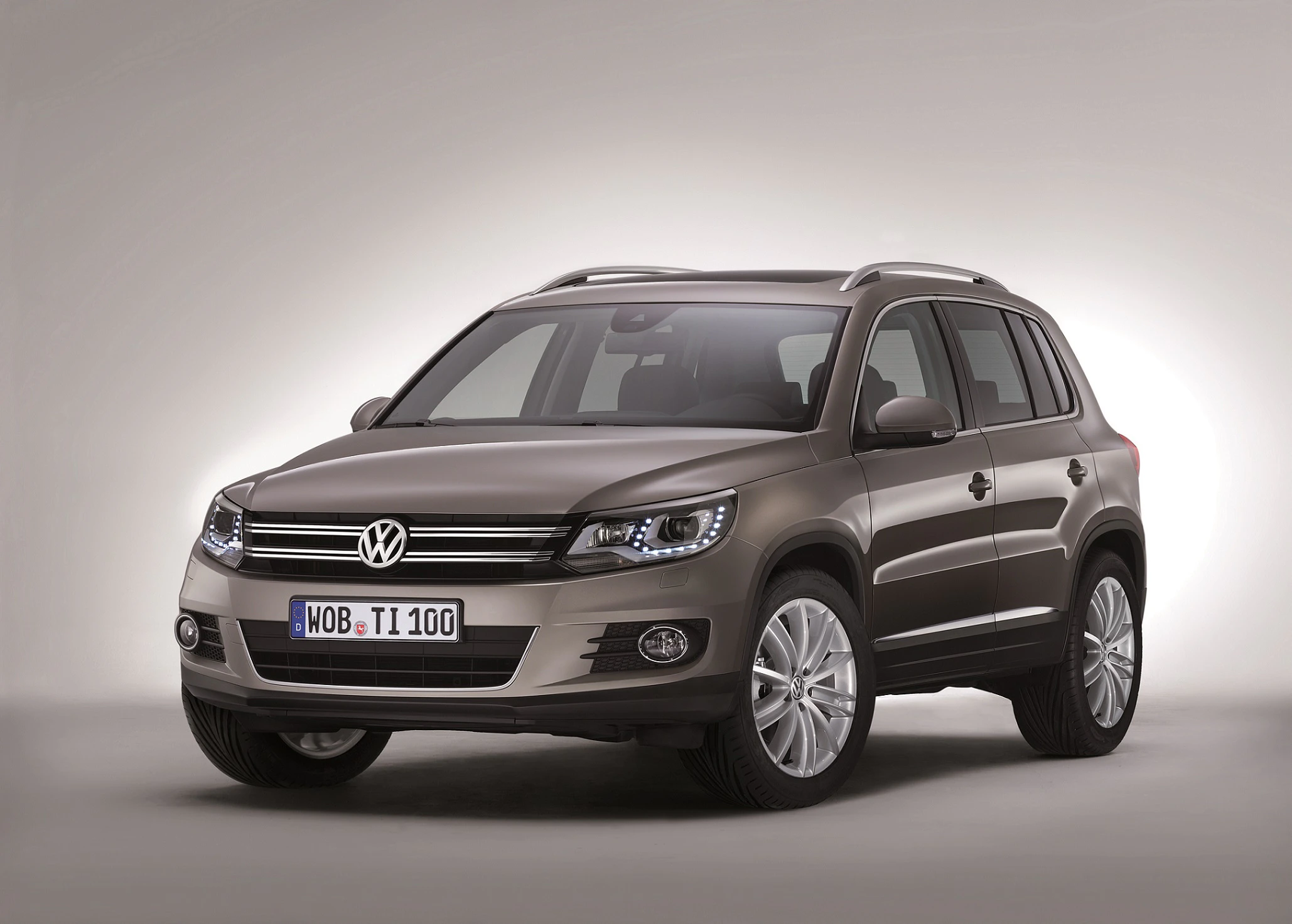 Brauner Volkswagen Tiguan SUV in einem Studio mit Beleuchtung. Das Nummernschild zeigt "WOB-TI100".