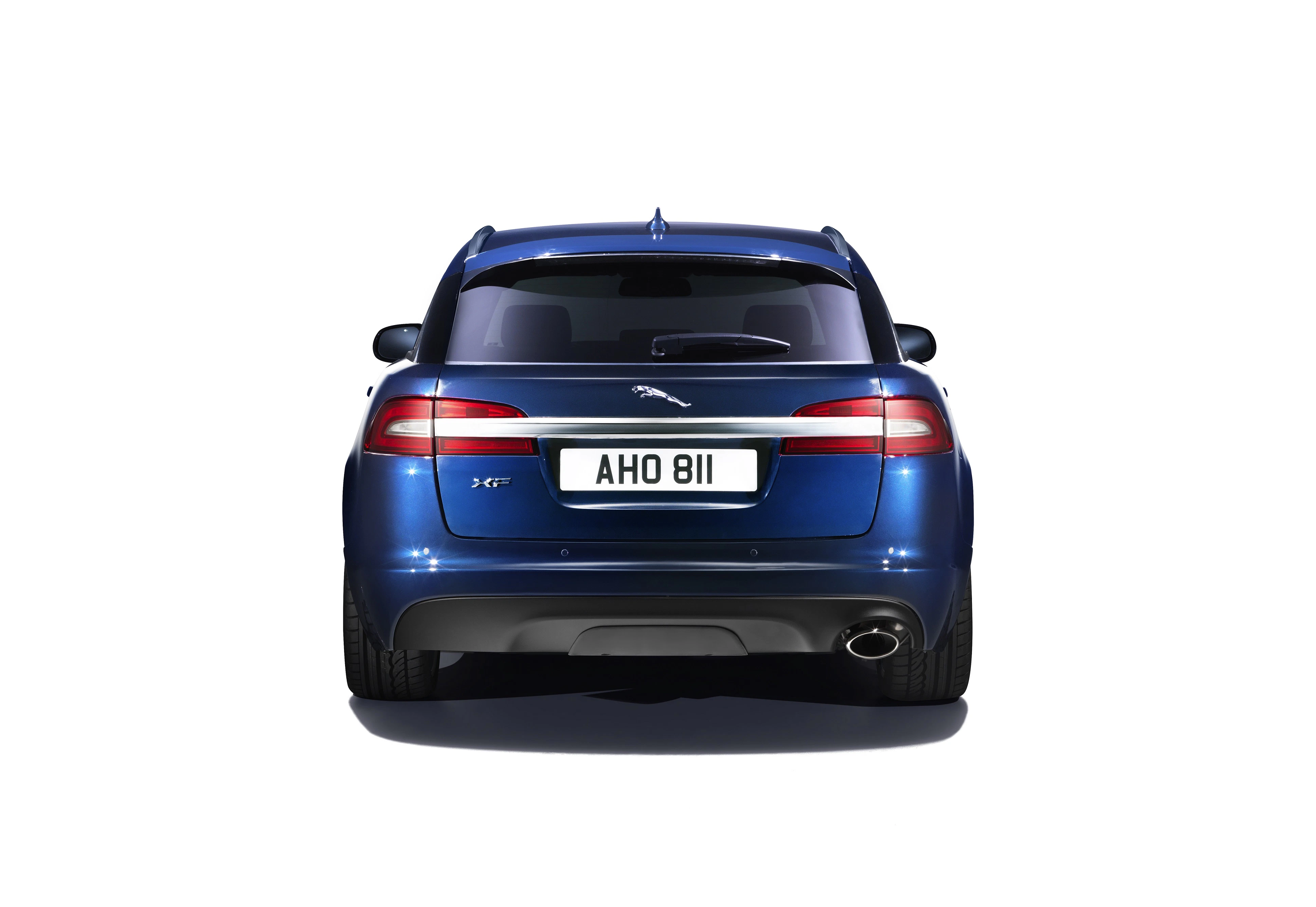 Blauer Sportwagen von hinten, mit glänzendem Lack und Emblem. Nummernschild: AHO 811. Elegantes, modernes Design.