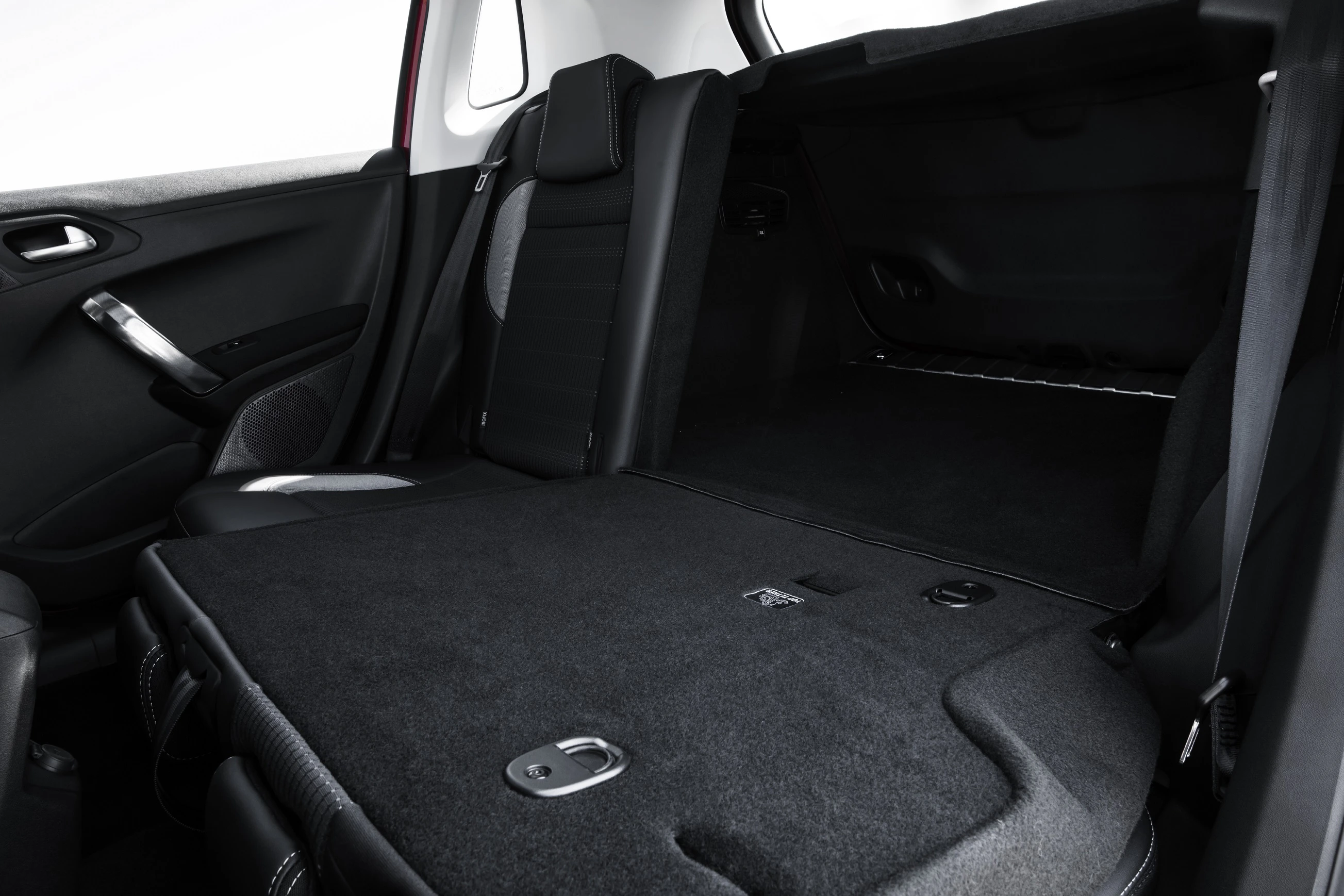 Rückbank eines Autos mit umgeklappten Sitzen, die einen erweiterten Kofferraum bilden. Dunkler Innenraum mit schwarzen Sitzpolstern.