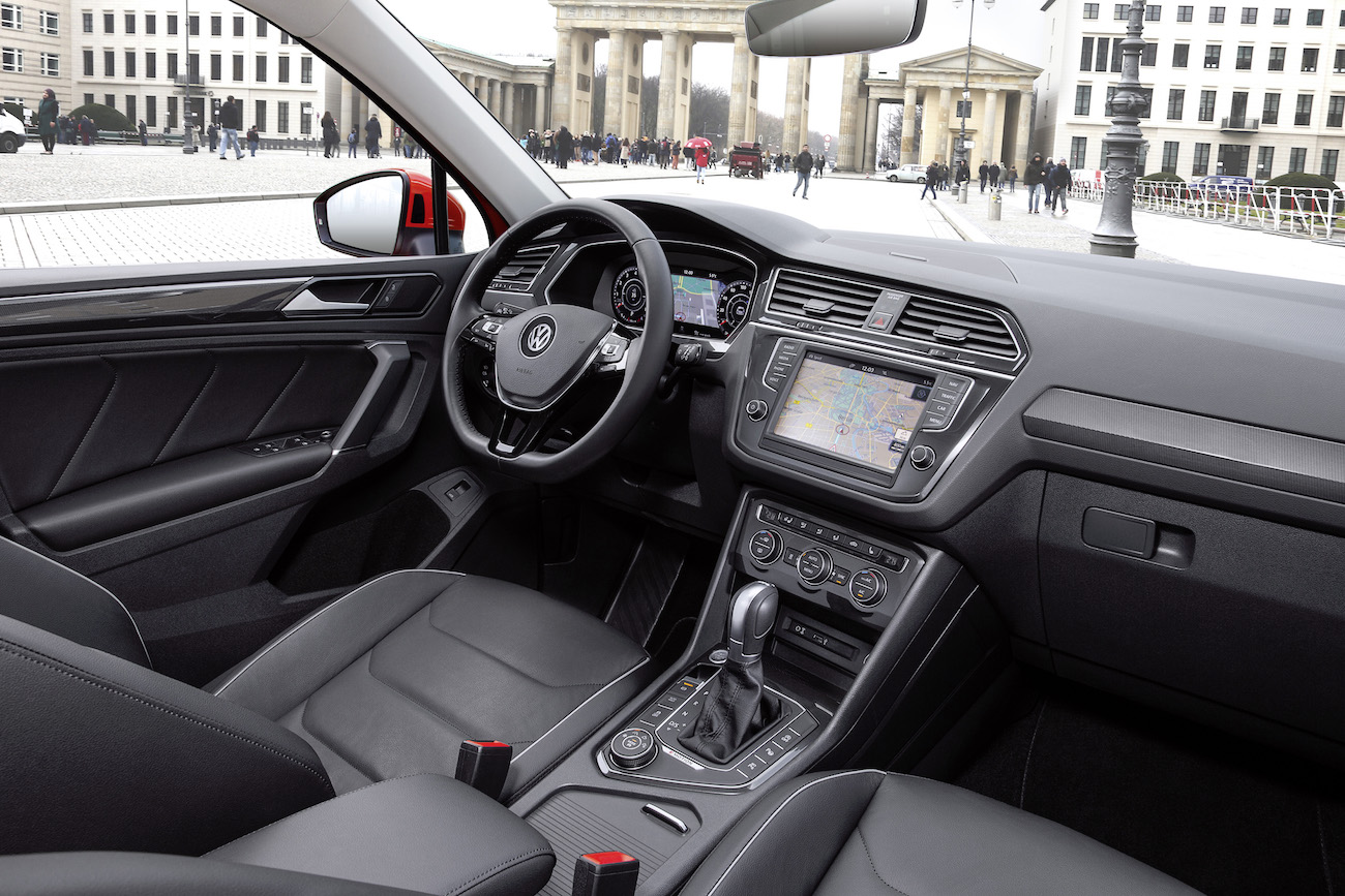 Innenraum eines modernen Volkswagen-Autos mit geparktem Blick auf das Brandenburger Tor, kombiniert Navigation und elegantes Design.