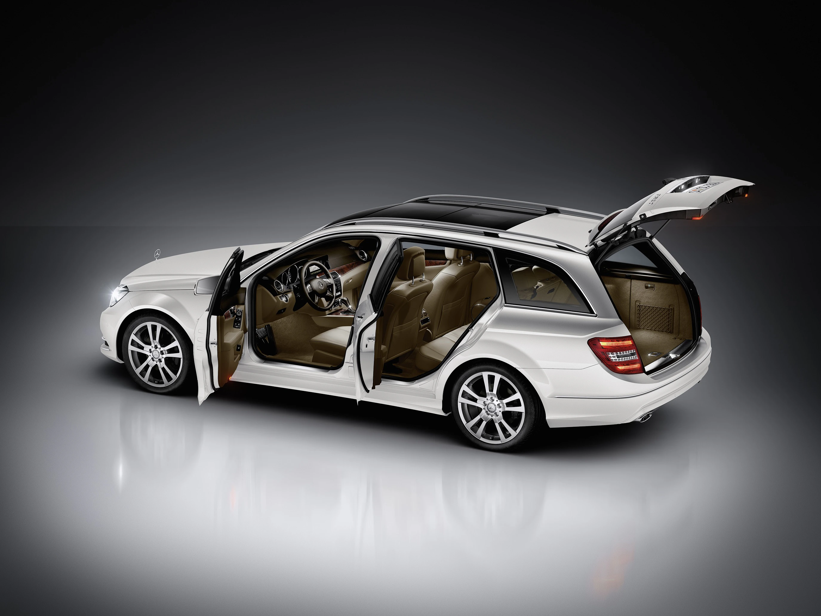 Weißer Kombi mit geöffneten Türen und Kofferraum, in einem Studio aufgenommen. Zeigt Innen- und Außendesign des Fahrzeugs.