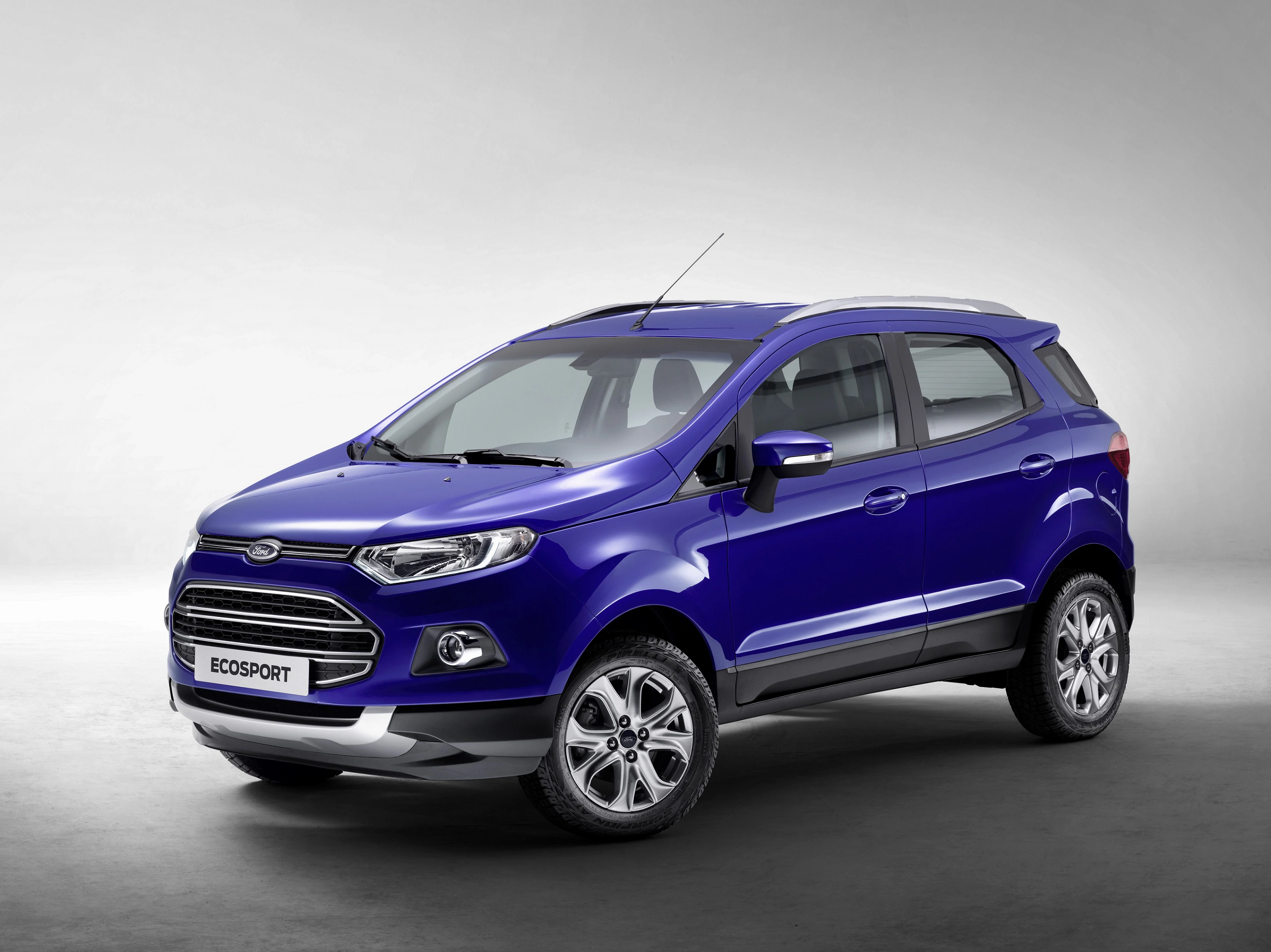Blauer Ford EcoSport SUV in einem hellen Raum, Seitenansicht. Silberne Felgen und dezente Dachreling sind sichtbar. Minimalistischer Hintergrund.