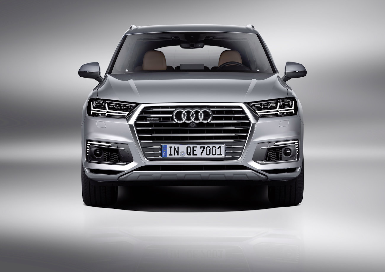 Silberner Audi-SUV, Frontansicht, mit LED-Scheinwerfern und charakteristischem Kühlergrill, auf grauem Hintergrund.