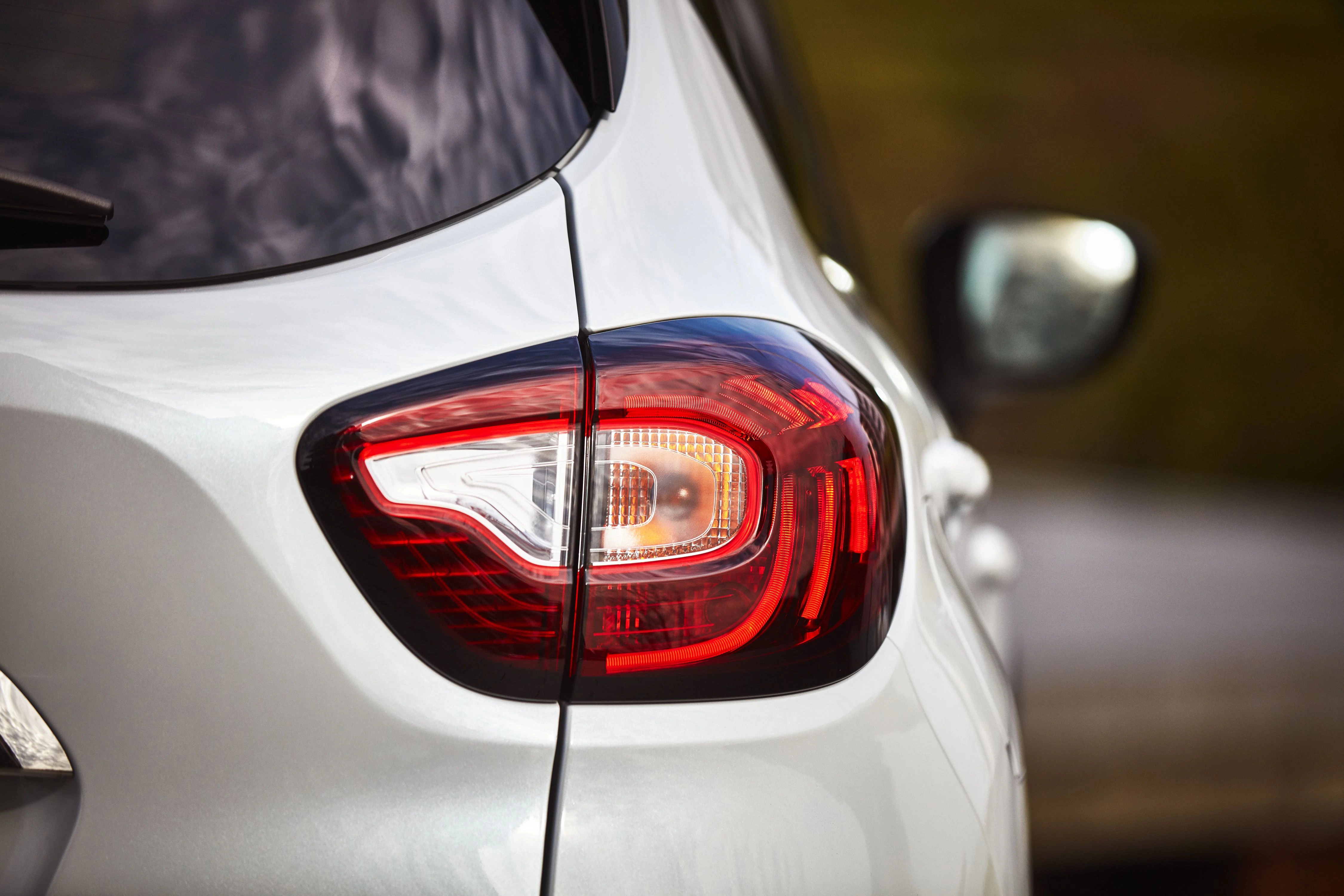 Rückansicht eines silbernen Autos mit einem modernen, leuchtenden Rücklicht.