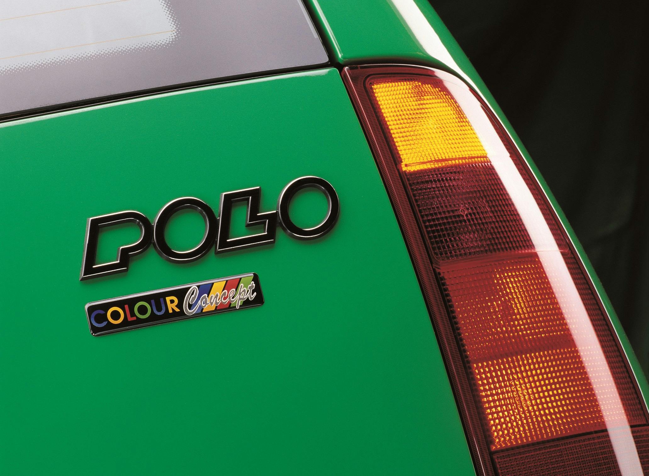 Nahaufnahme eines grünen VW Polo mit "Colour Concept"-Emblem an der Heckleuchte.