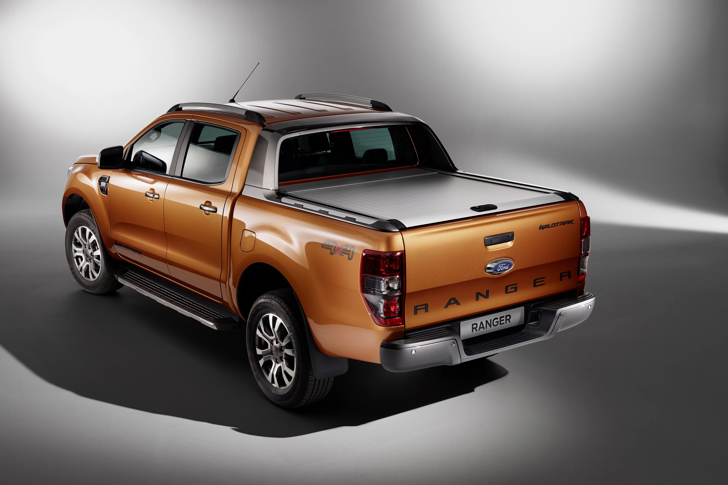 Bronzefarbener Pickup-Truck, in einem Studio fotografiert, mit erkennbaren Details wie Ladefläche und markanten Radkästen.