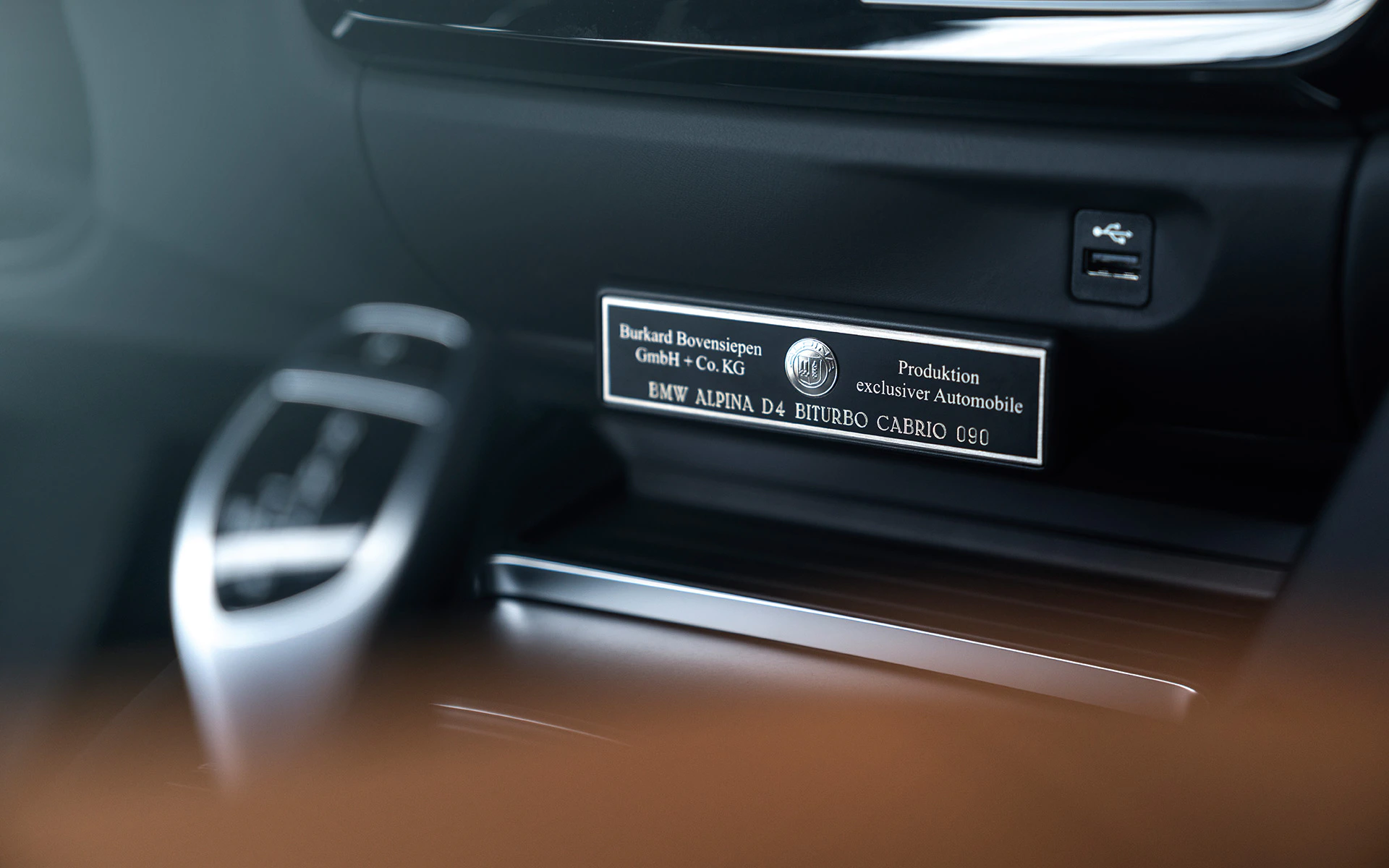 Nahaufnahme eines Fahrzeuginnenraums mit einem Metallplakettenschild von Alpina, das die Seriennummer und Modellinformationen zeigt.