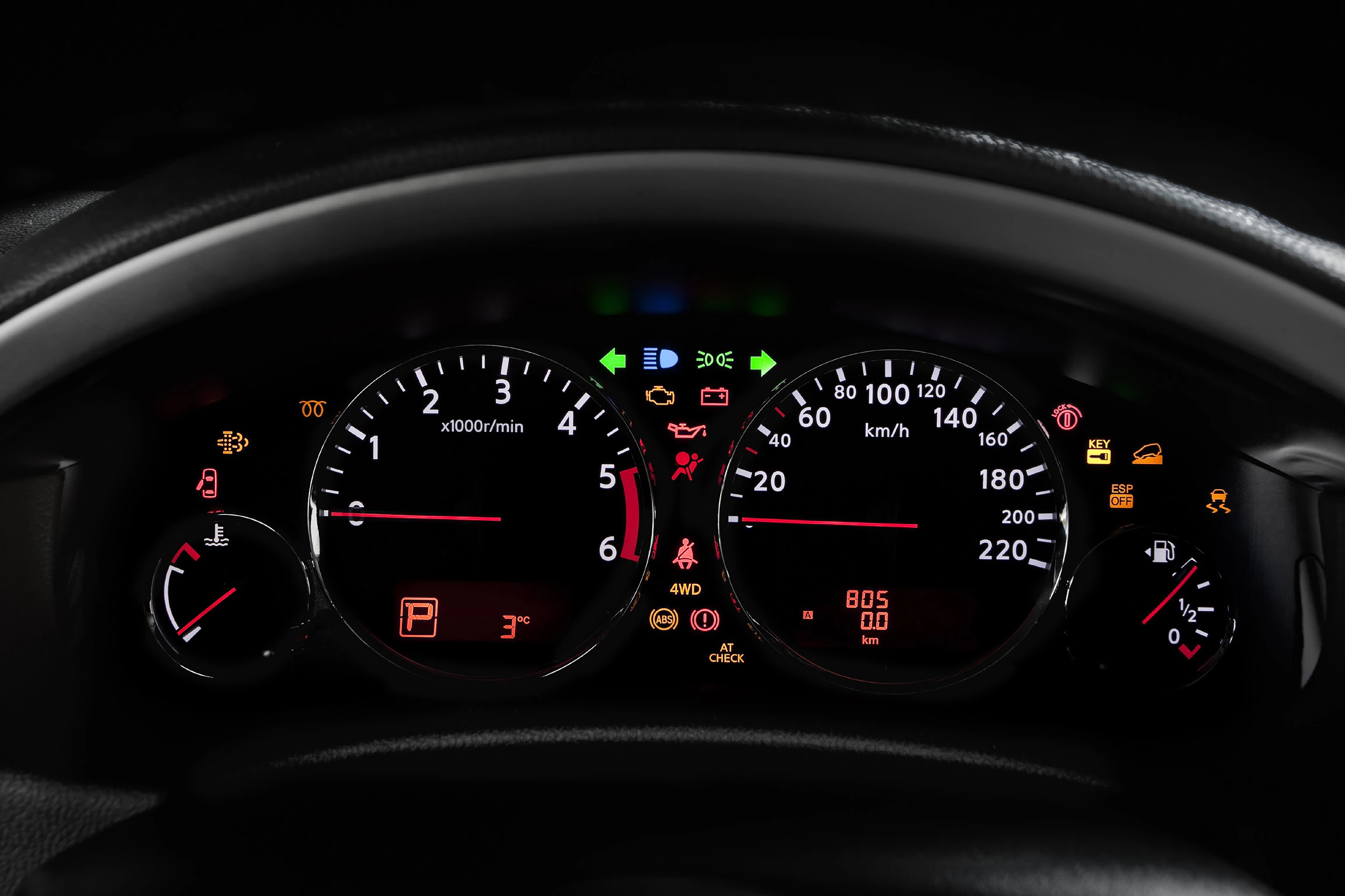 Armaturenbrett eines Autos mit leuchtenden Anzeigen und Symbolen, einschließlich Drehzahlmesser, Tachometer und verschiedenen Warnleuchten.