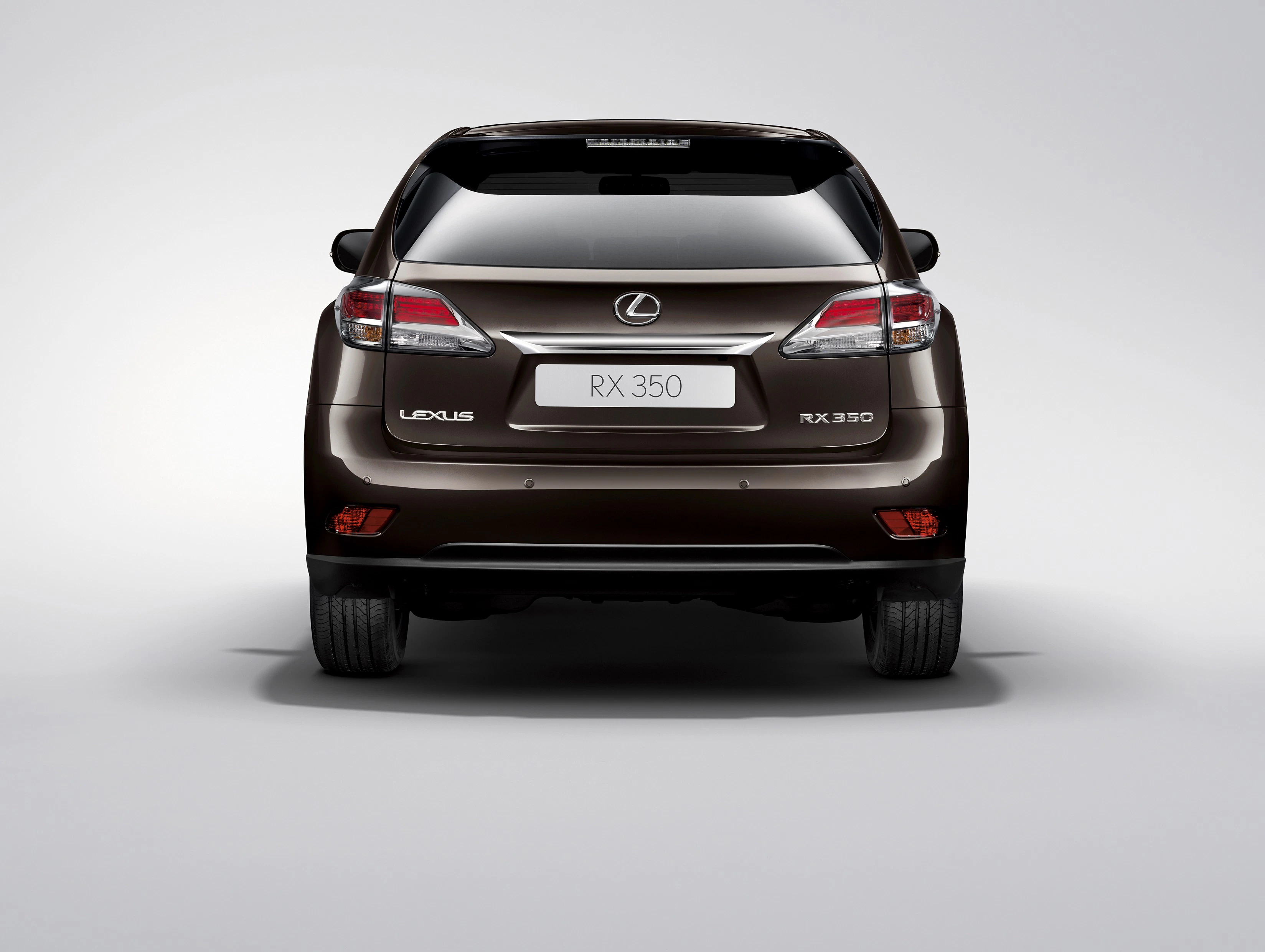 Rückansicht eines braunen Lexus RX 350 vor einem grauen Hintergrund. Fahrzeug zeigt Logo und Modellname.