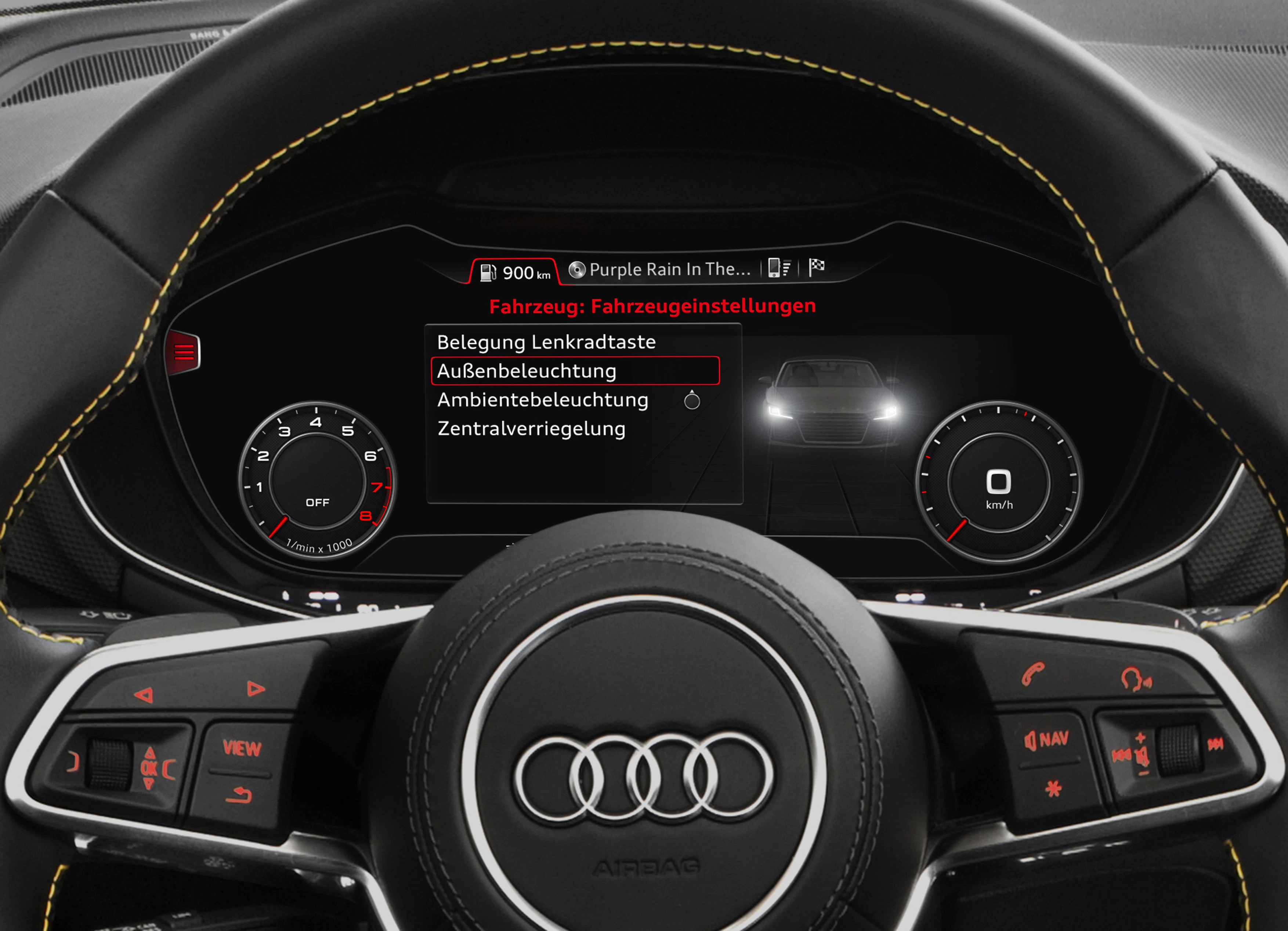 Nahaufnahme eines Audi-Lenkrads und digitalen Armaturenbretts, das Fahrzeug- und Beleuchtungseinstellungen zeigt.