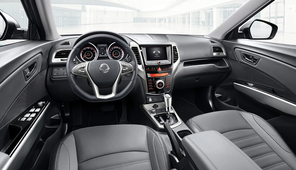 Innenraum eines modernen Autos mit Lederlenkrad, Touchscreen, vielen Kontrollen, schwarzen Ledersitzen und elegante Armaturenbrett-Details.