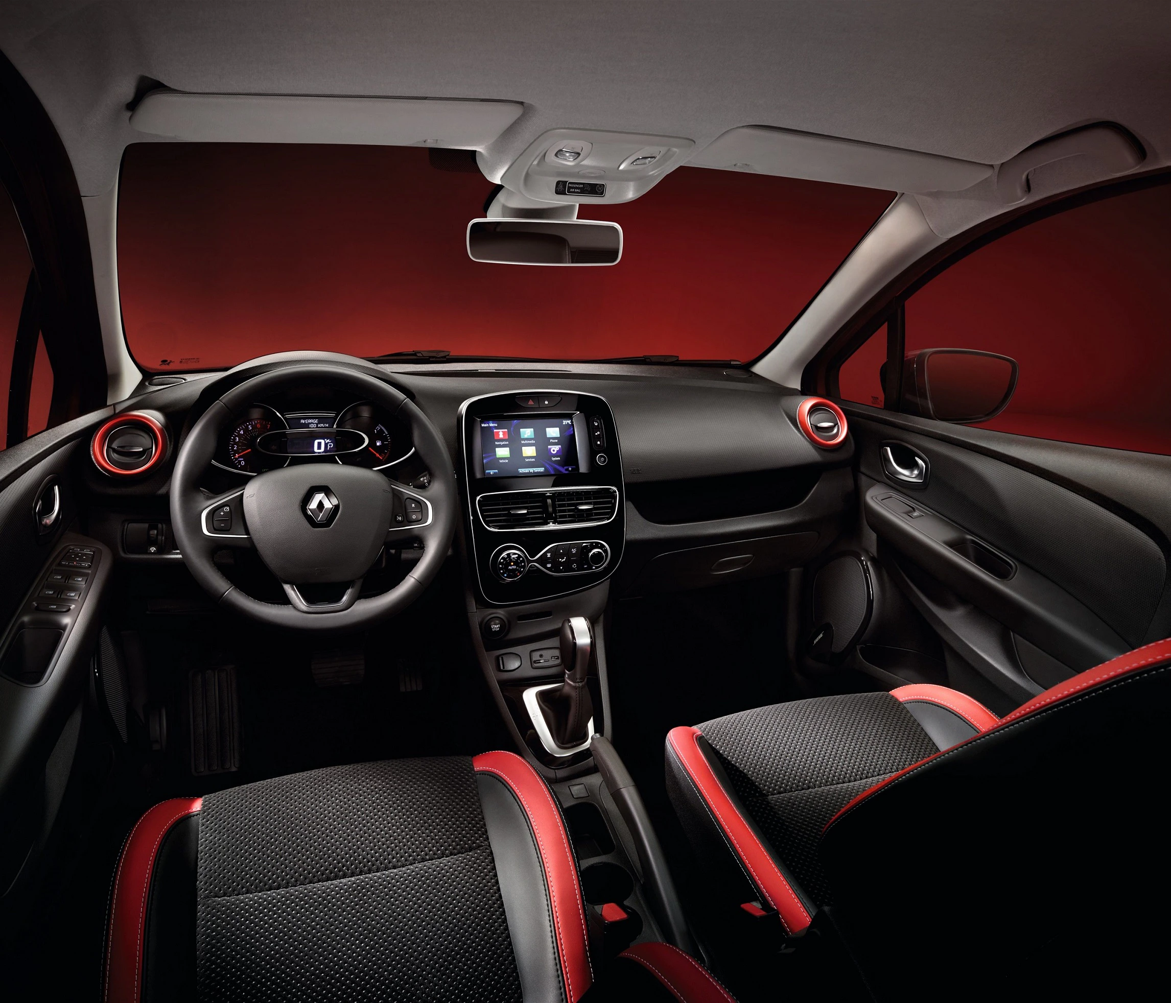 Innenraum eines modernen Autos mit schwarzem und rotem Interieur, digitales Armaturenbrett und Touchscreen-Display in der Mittelkonsole.