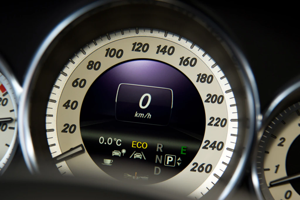 Nahaufnahme eines Tacho-Displays eines Autos, zeigt 0 km/h, verschiedene Informationen wie Temperatur und Eco-Modusstatus.