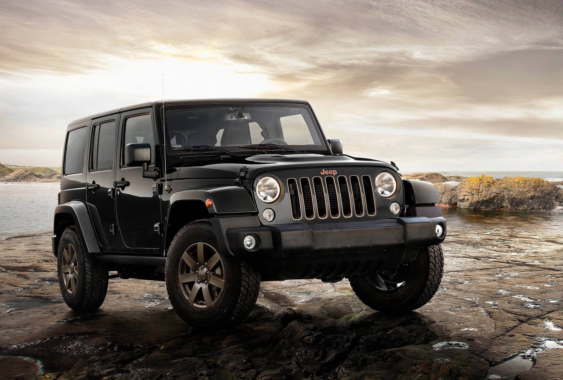 Schwarzer Jeep auf felsigem Terrain vor bewölktem Himmel, seitliche Ansicht, mit großen Reifen und markanter Frontpartie.