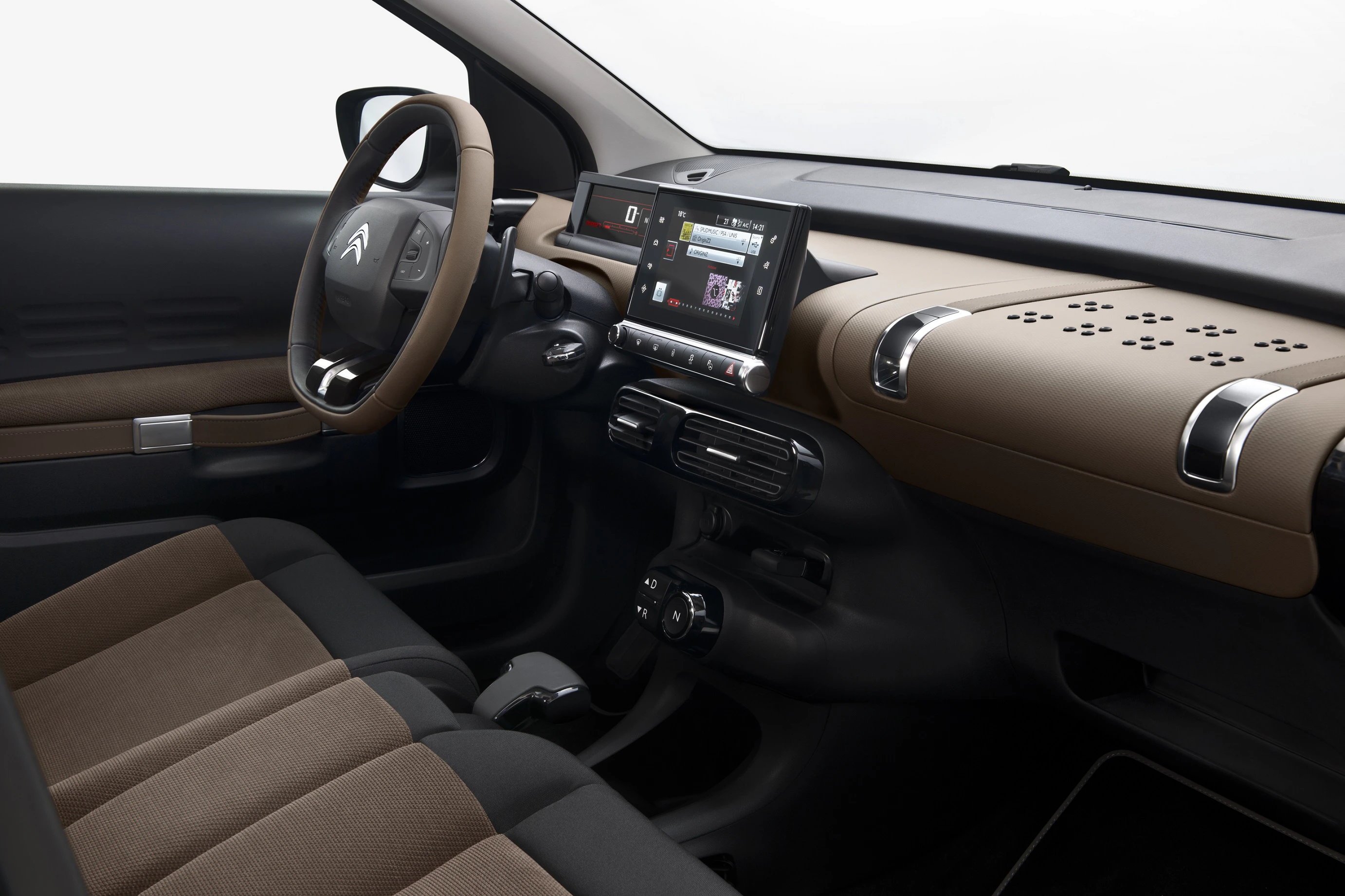 Innenraum eines Autos mit modernem Armaturenbrett, braun-schwarzen Sitzen, Infotainment-Bildschirm und elegantem Lenkrad.