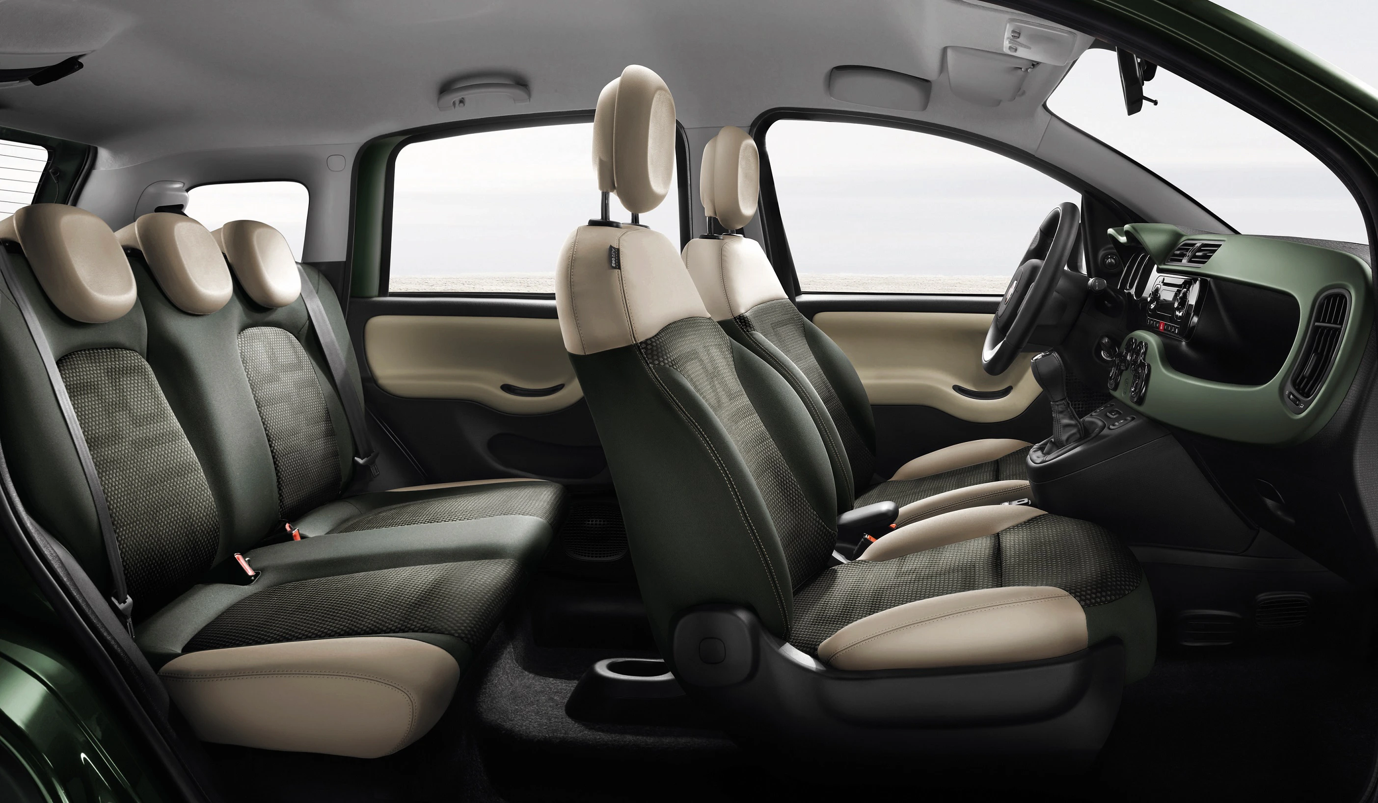Innenraum eines Autos mit grünen und beigen Sitzen, fünf Sitzplätze, modernes Armaturenbrett, Schaltknüppel in der Mittelkonsole.