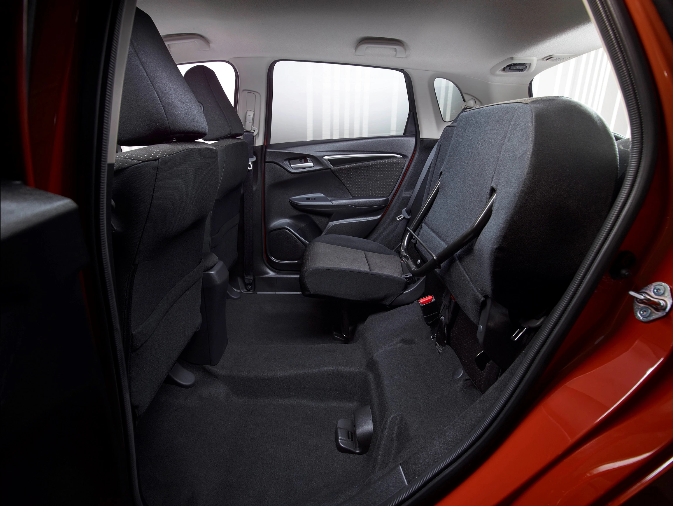 Rückansicht des Innenraums eines Autos mit hochgeklappten Rücksitzen, zeigt geräumigen Laderaum und schwarze Polsterung.