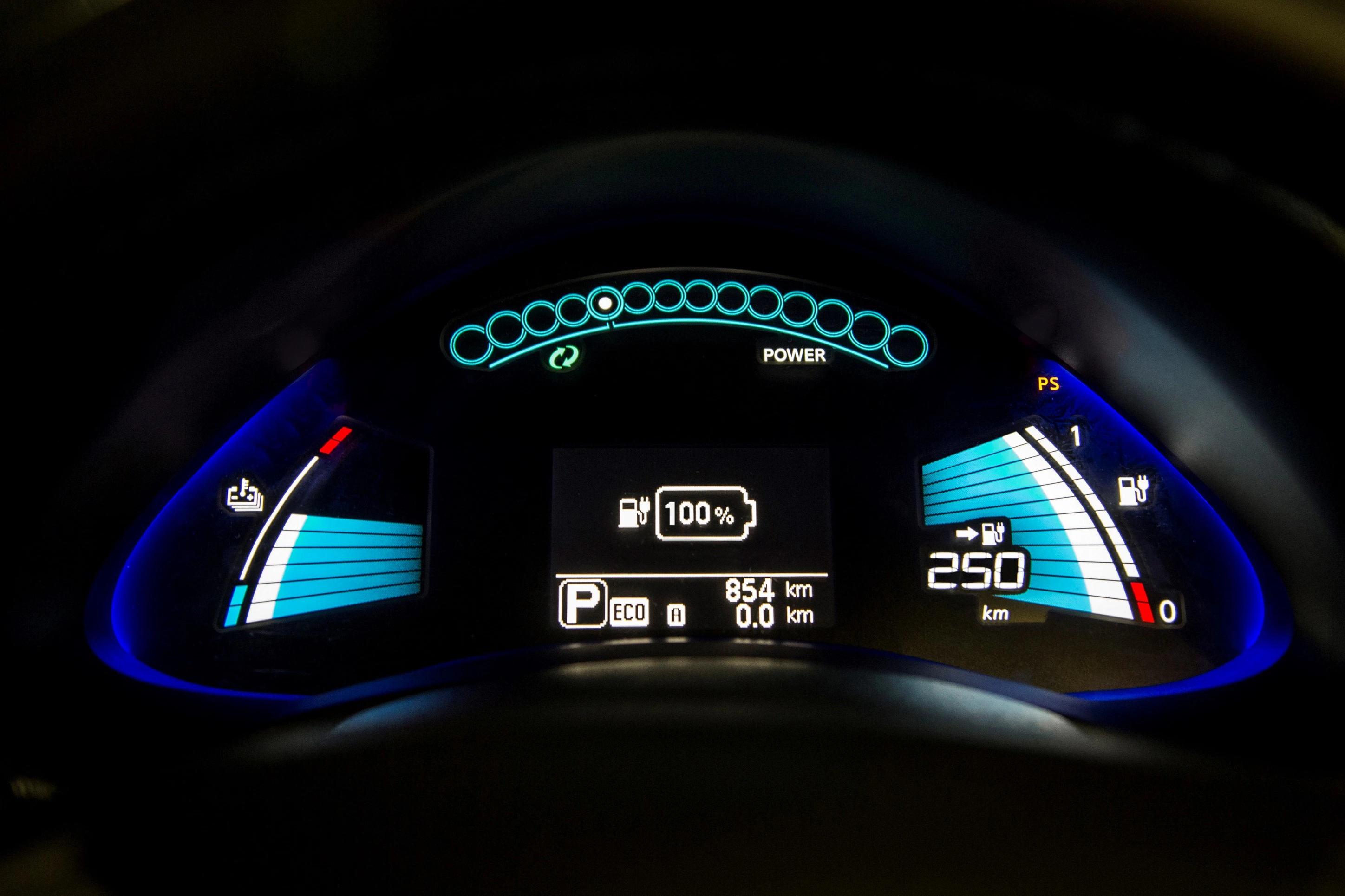 Batterieanzeige eines Elektroautos mit 100 % Ladestand, verbleibender Reichweite von 250 km und leuchtenden blauen Elementen im Armaturenbrett.