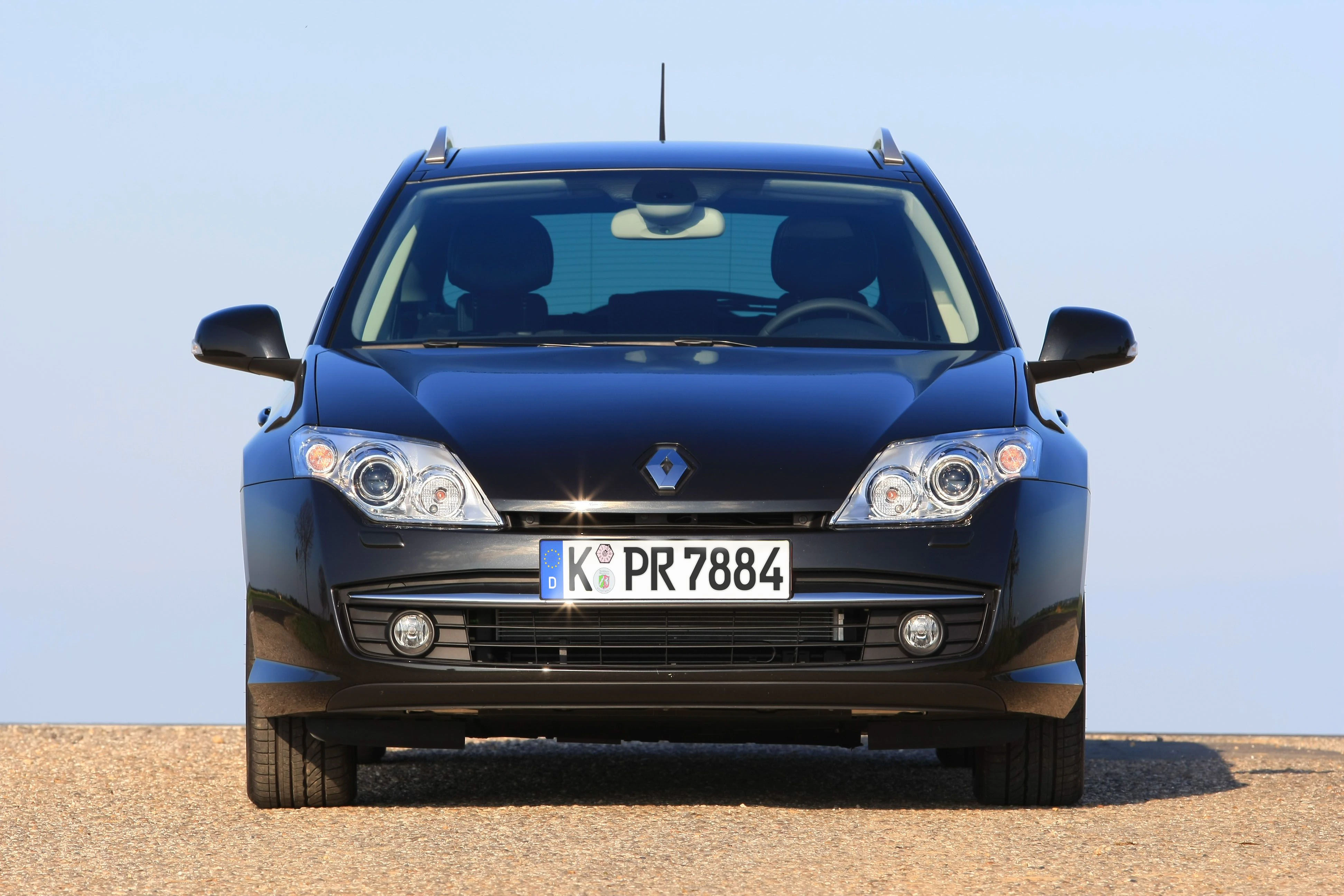 Schwarzer Renault Laguna von vorne auf einer Straße vor klarem Himmel, mit deutschem Nummernschild „K PR 7884“.